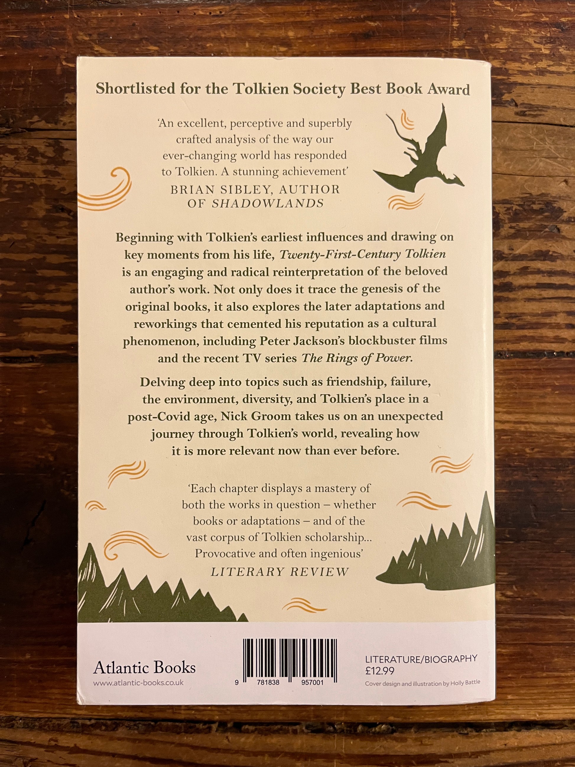 Back cover of book titled 'Twenty-First-Century Tolkien' by Nick Groom on a wooden surface