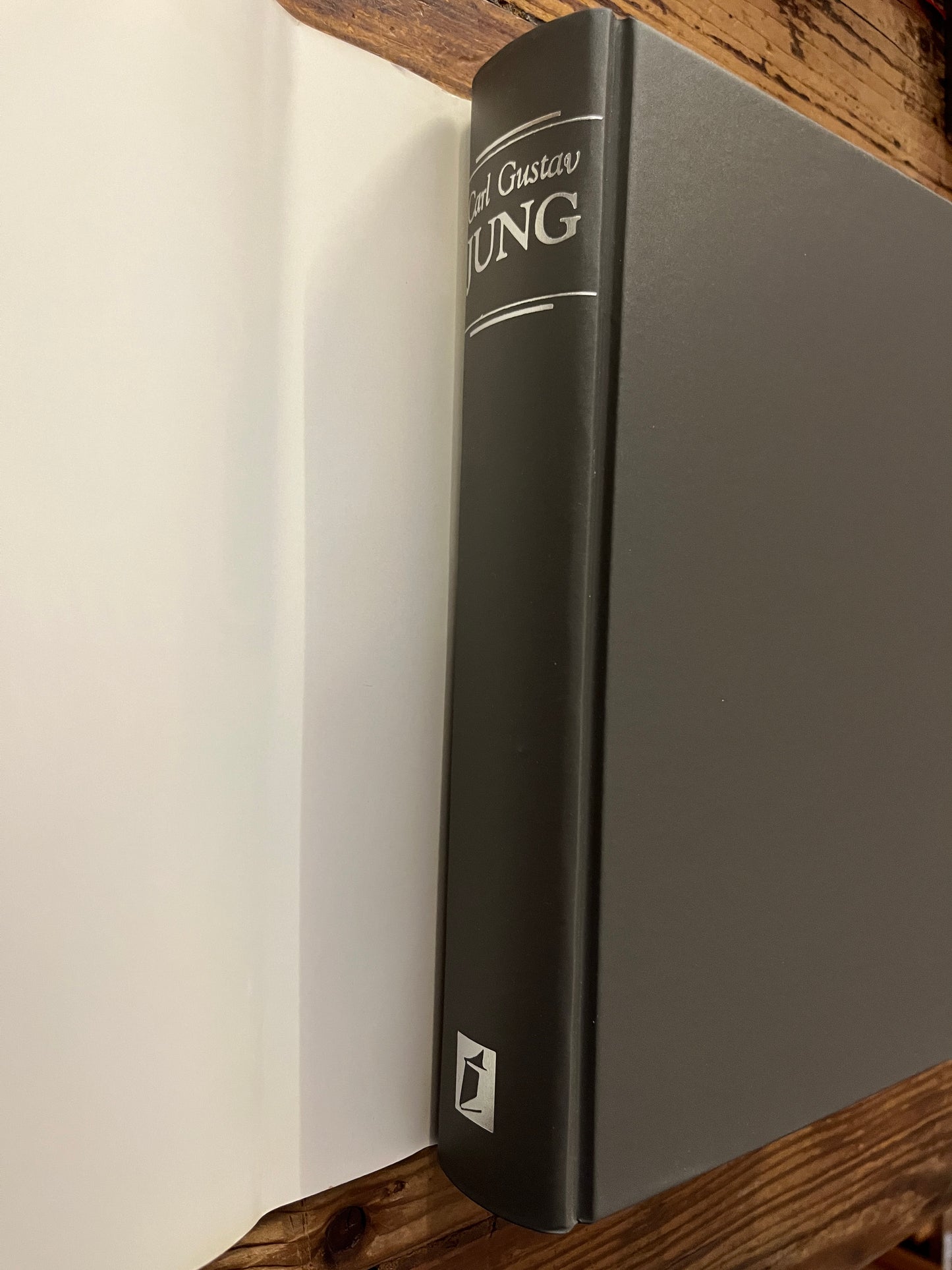 Rug van boek met de titel 'Carl Gustav Jung, zijn leven en Werk' op een houten achtergrond 