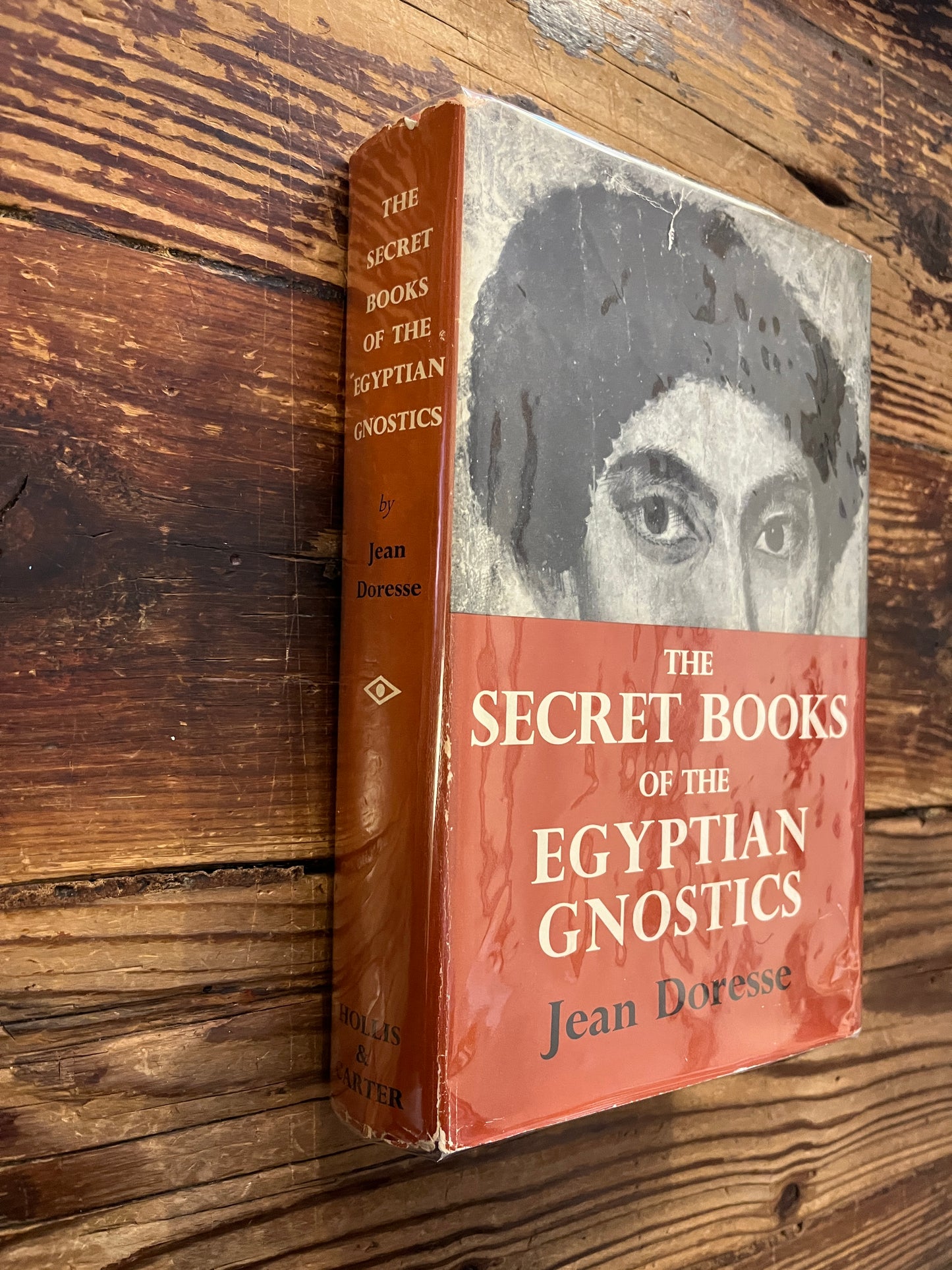 Book titled 'The Secret Books of the Egyptian Gnostics' by Jean Doresse on a wooden surface