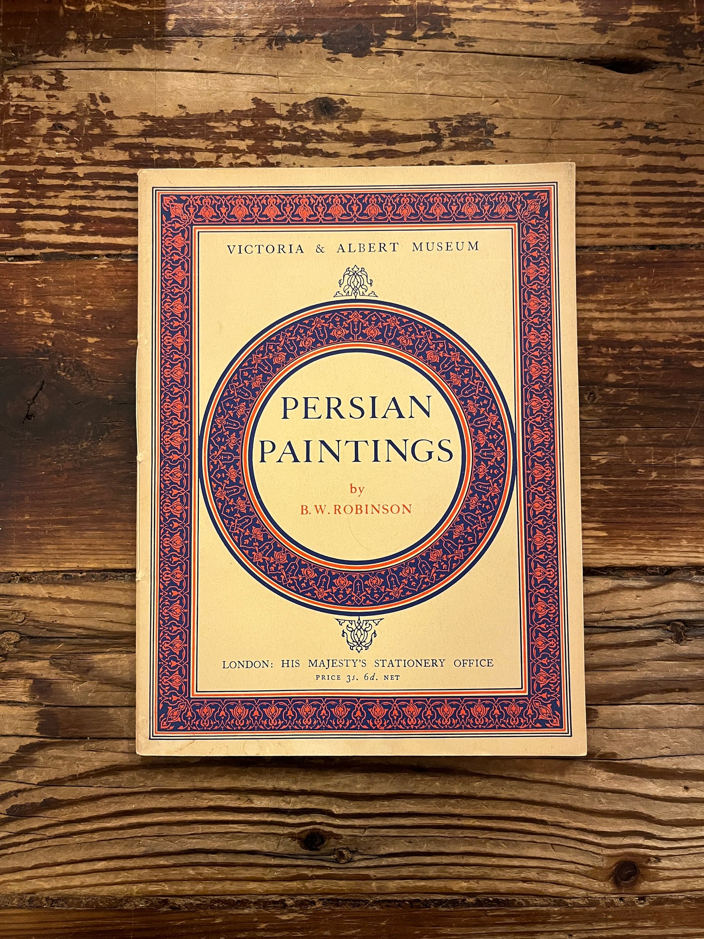 Book titled 'Persian Paintings' by A.W. Robinson on a wooden surface