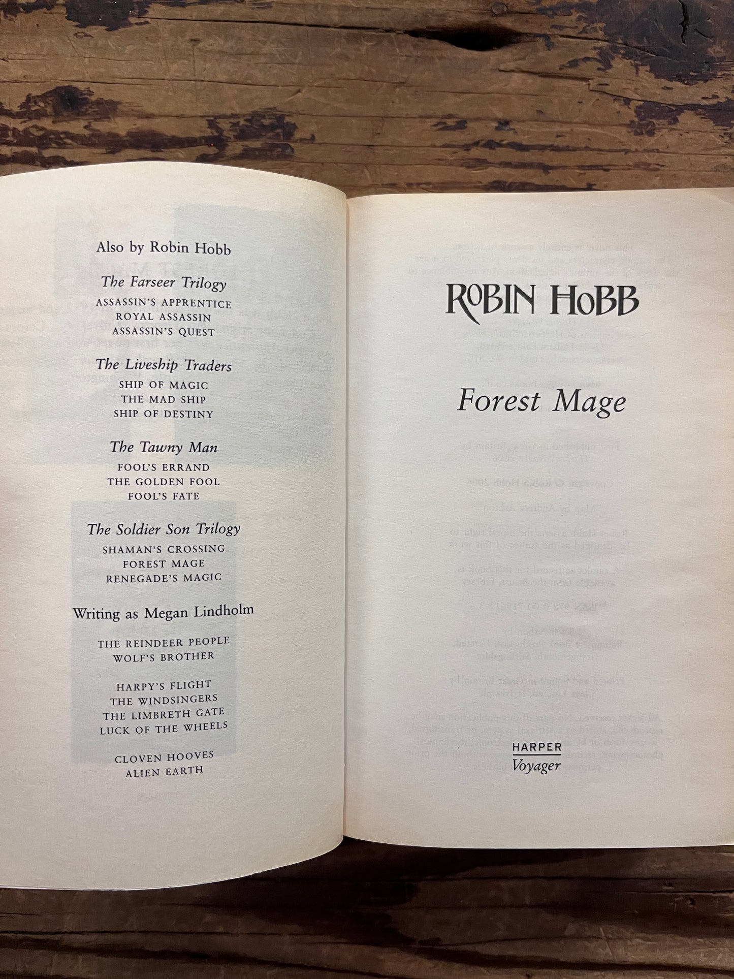 Open book titled 'Forest Mage' by Robin Hobb on a wooden surface