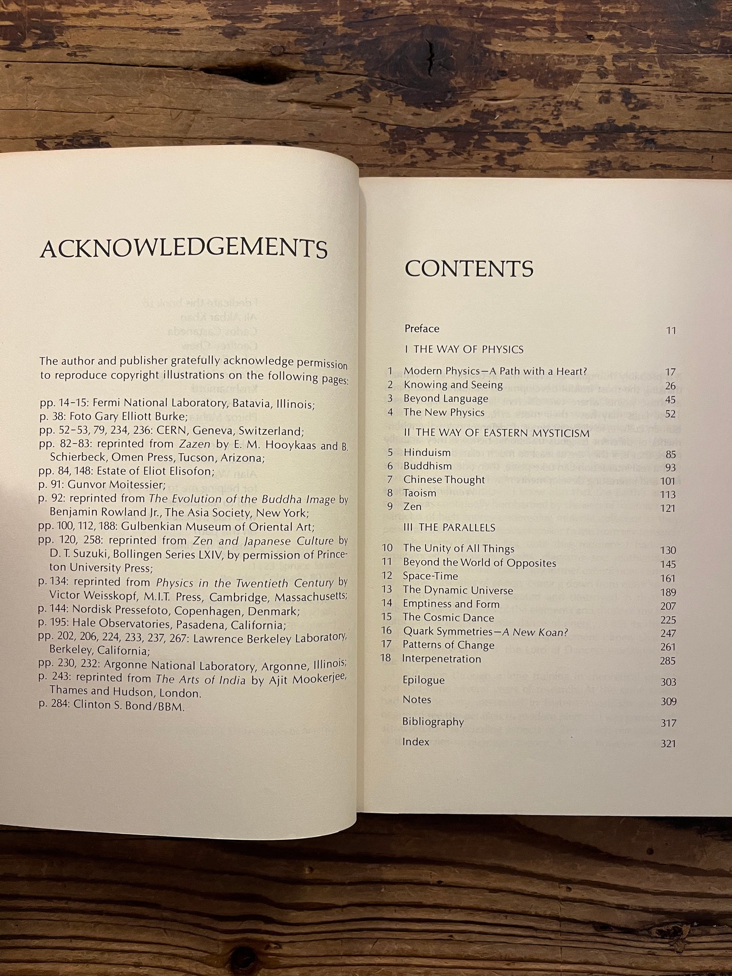 Open book titled 'The Tao of Physics' by Fritjof Capra on a wooden surface