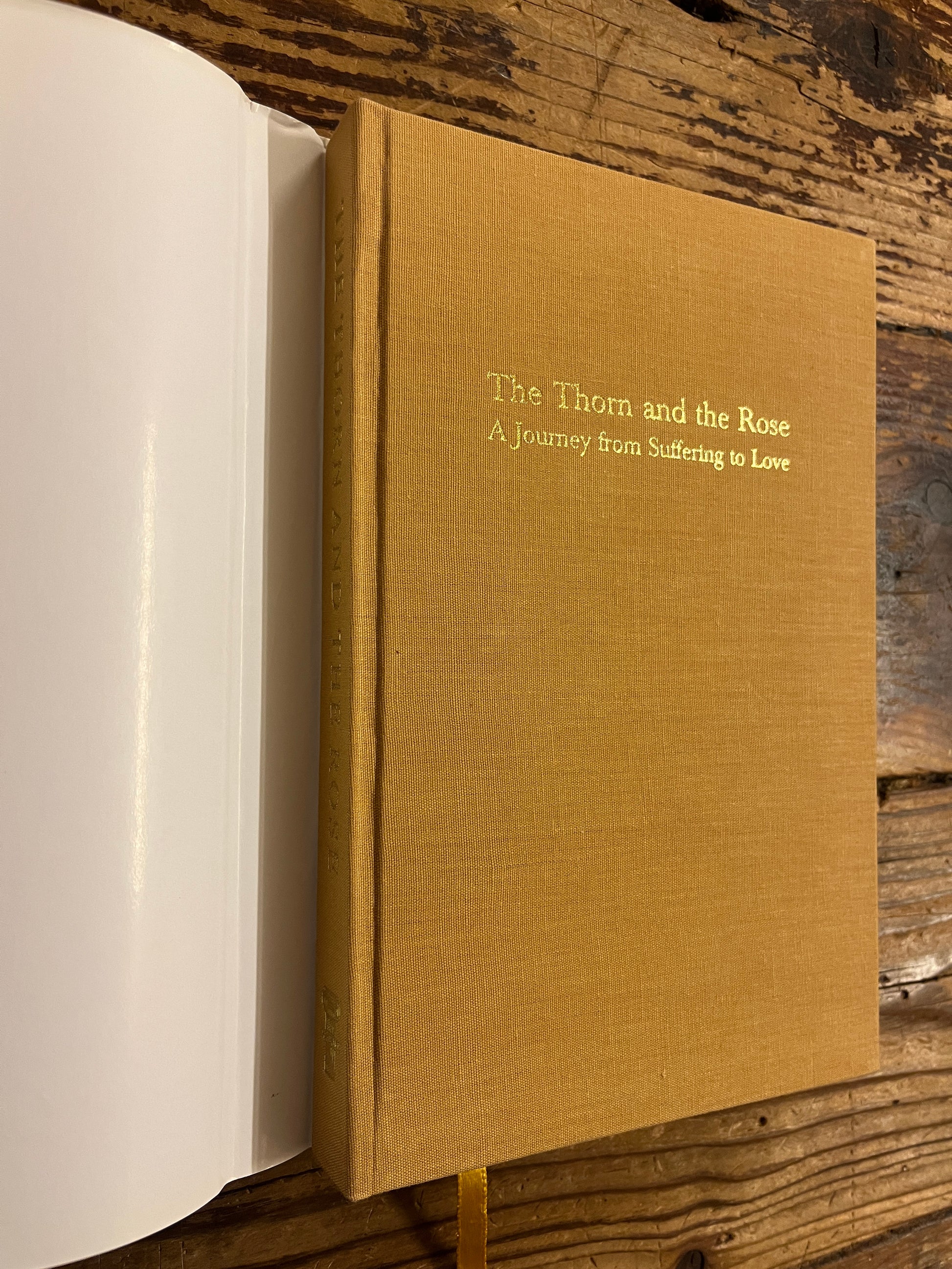 Book titled 'The Thorn and the Rose' on a wooden surface without dust jacket 