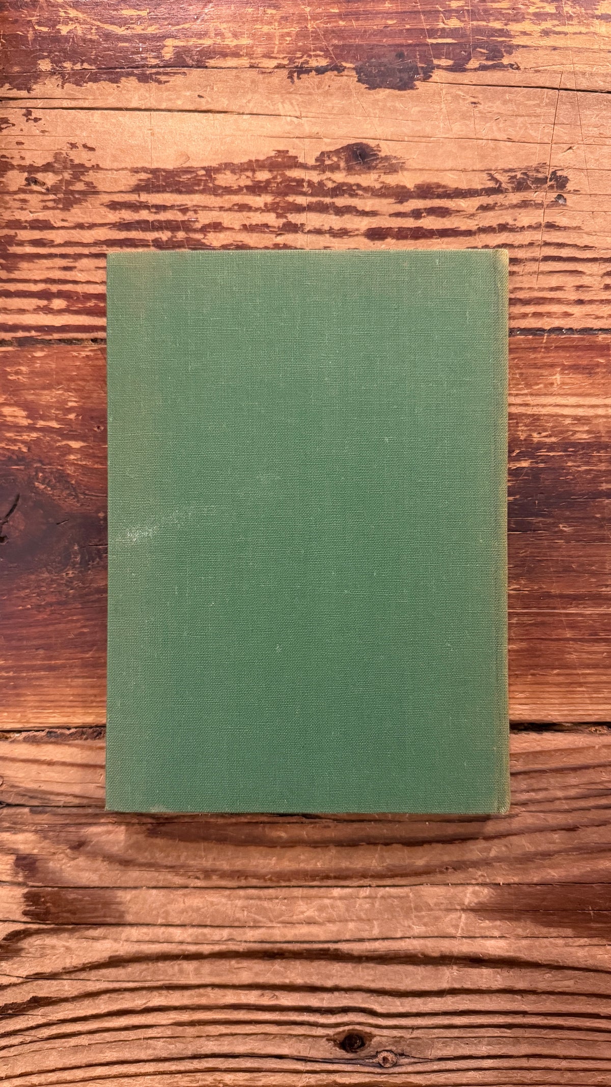 Achterkant van een boek met de titel 'De Vierde Wijze uit het Oosten' door Henry van Dyke op een houten achtergrond