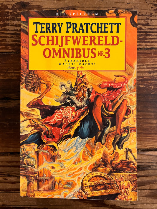 Voorkan van boek met de titel 'Terry Pratchett Schijfwereld Omnibus n 3' op een houten achtergrond 