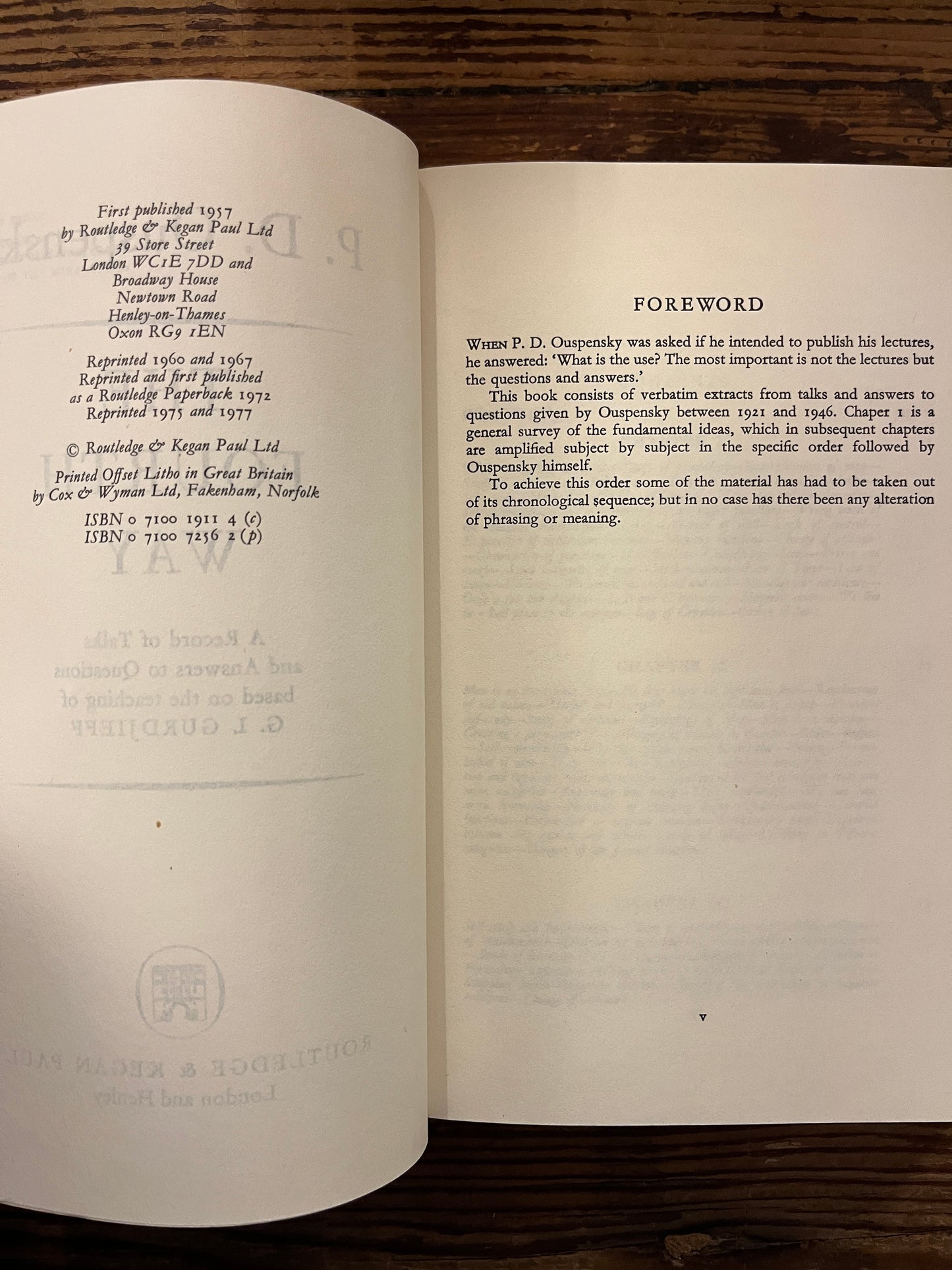 Open book with the title 'the fourth way' by P.D. Ouspensky on a wooden surface 