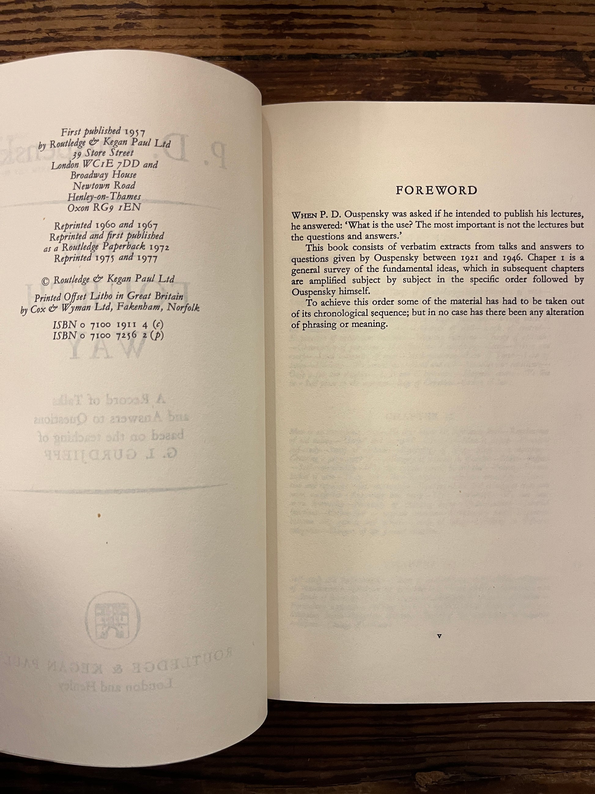 Open book with the title 'the fourth way' by P.D. Ouspensky on a wooden surface 