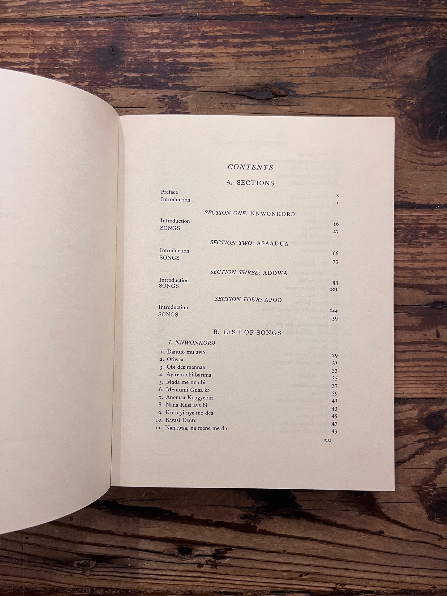 Contents of book titled 'Folk Songs of Ghana' by J.H. Kwabena Nketia on a wooden surface 