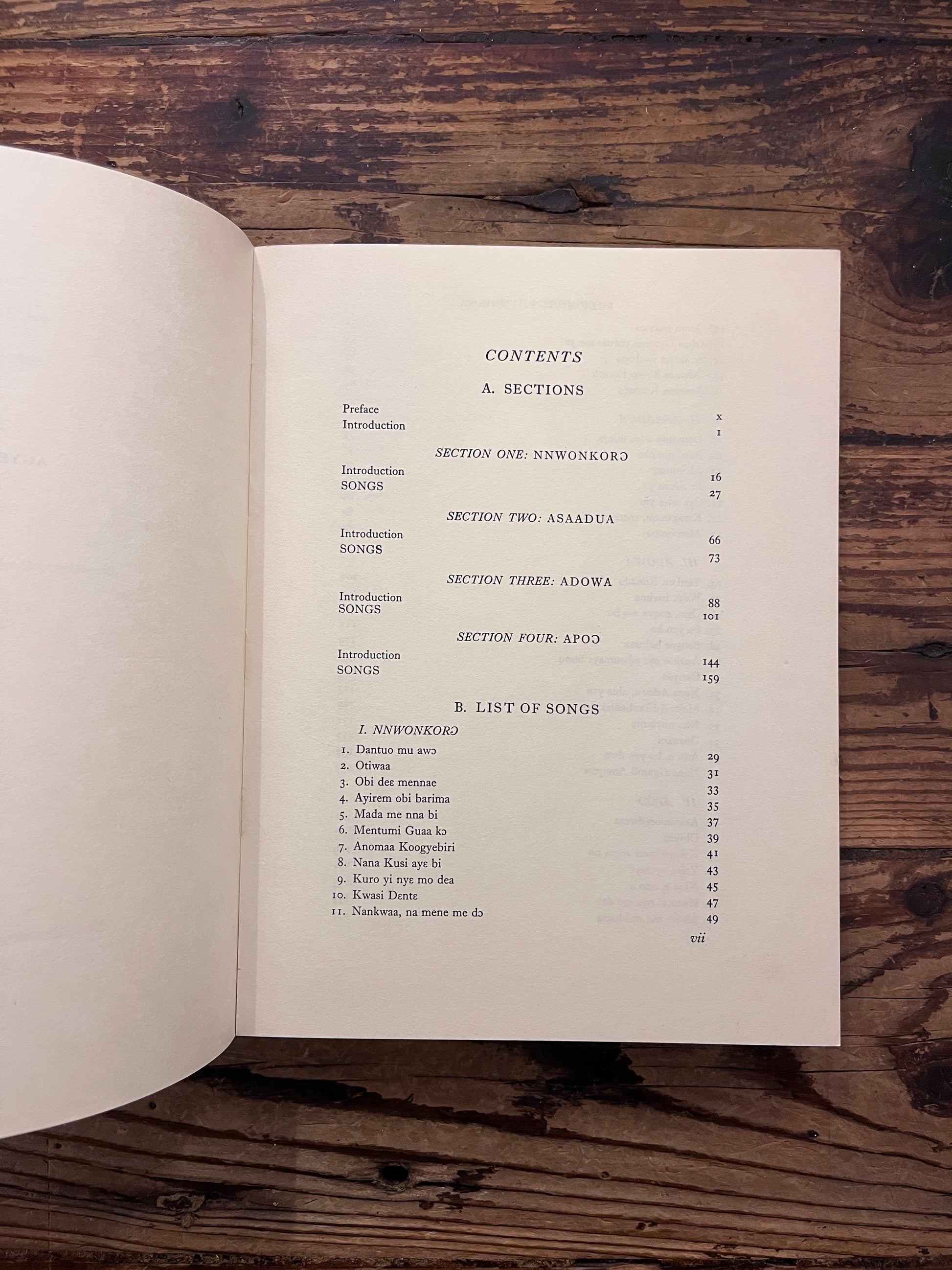 Contents of book titled 'Folk Songs of Ghana' by J.H. Kwabena Nketia on a wooden surface 