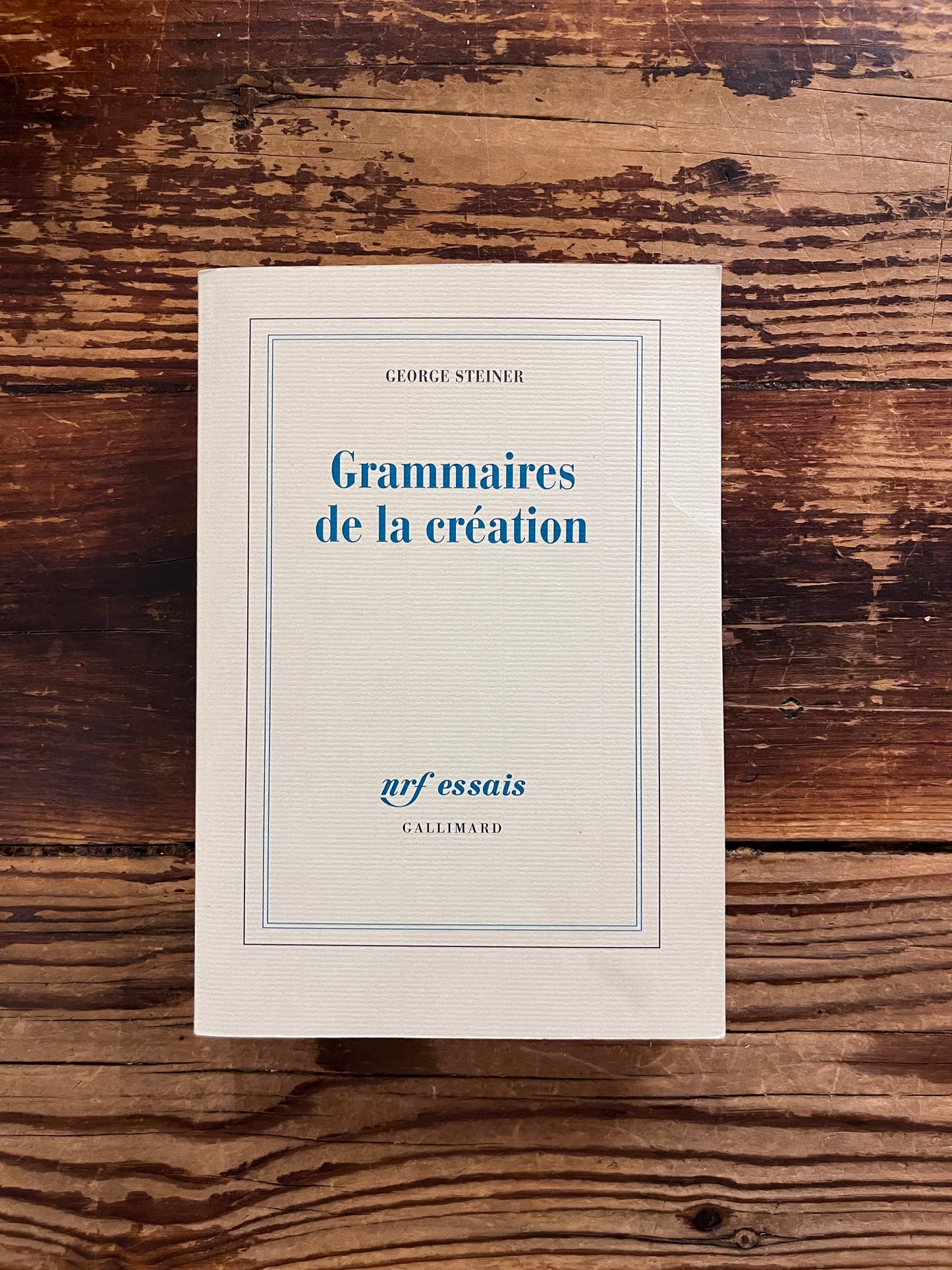 photo de la couverture du livre "grammaires de la creation"sur fond de bois