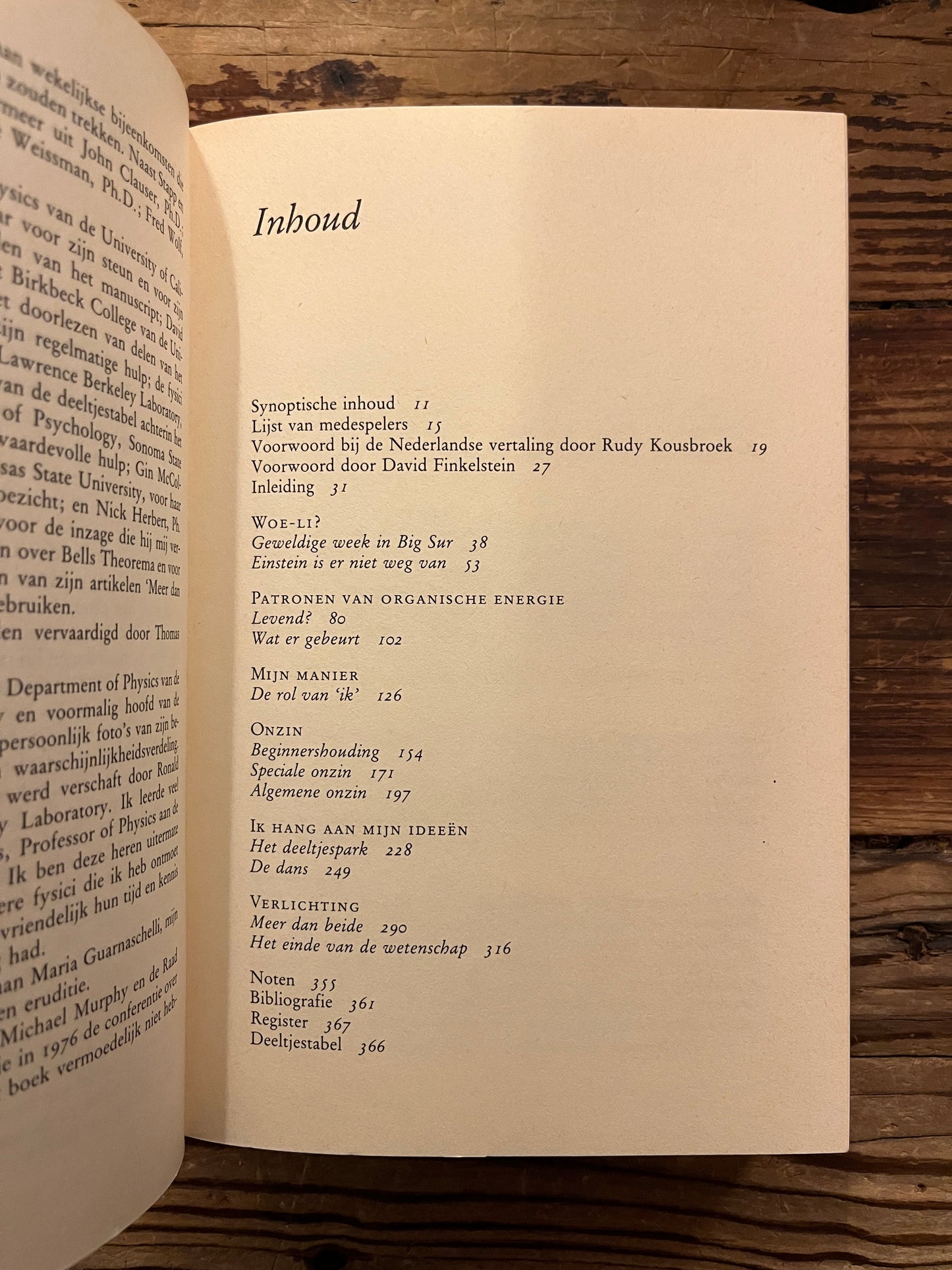 Open boek met de titel 'De Dansende Woe-Li Meesters' door Gary Zukav op een houten achtergrond