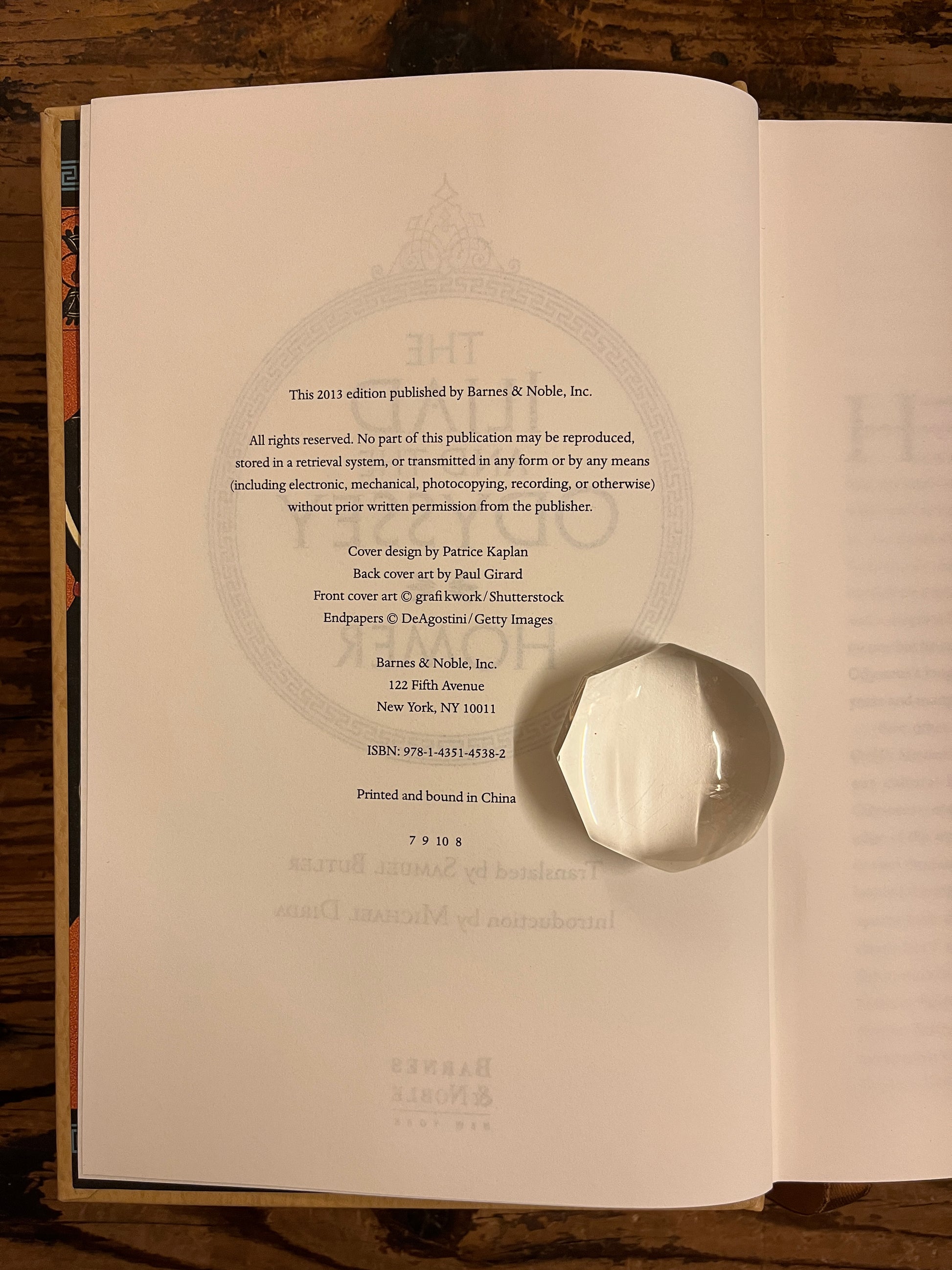 photot of the edition information page from the book "the iliad and the odyssey" on a wooden backround