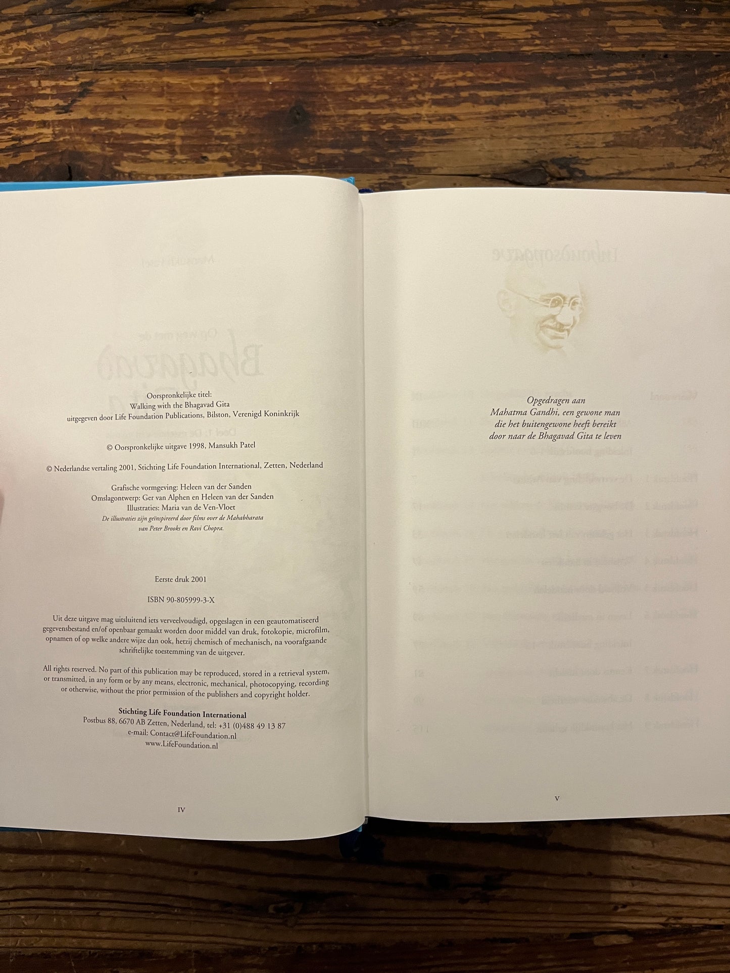 Open boek met de titel 'Op weg met de Bhagavad Gita' op een houten achtergrond