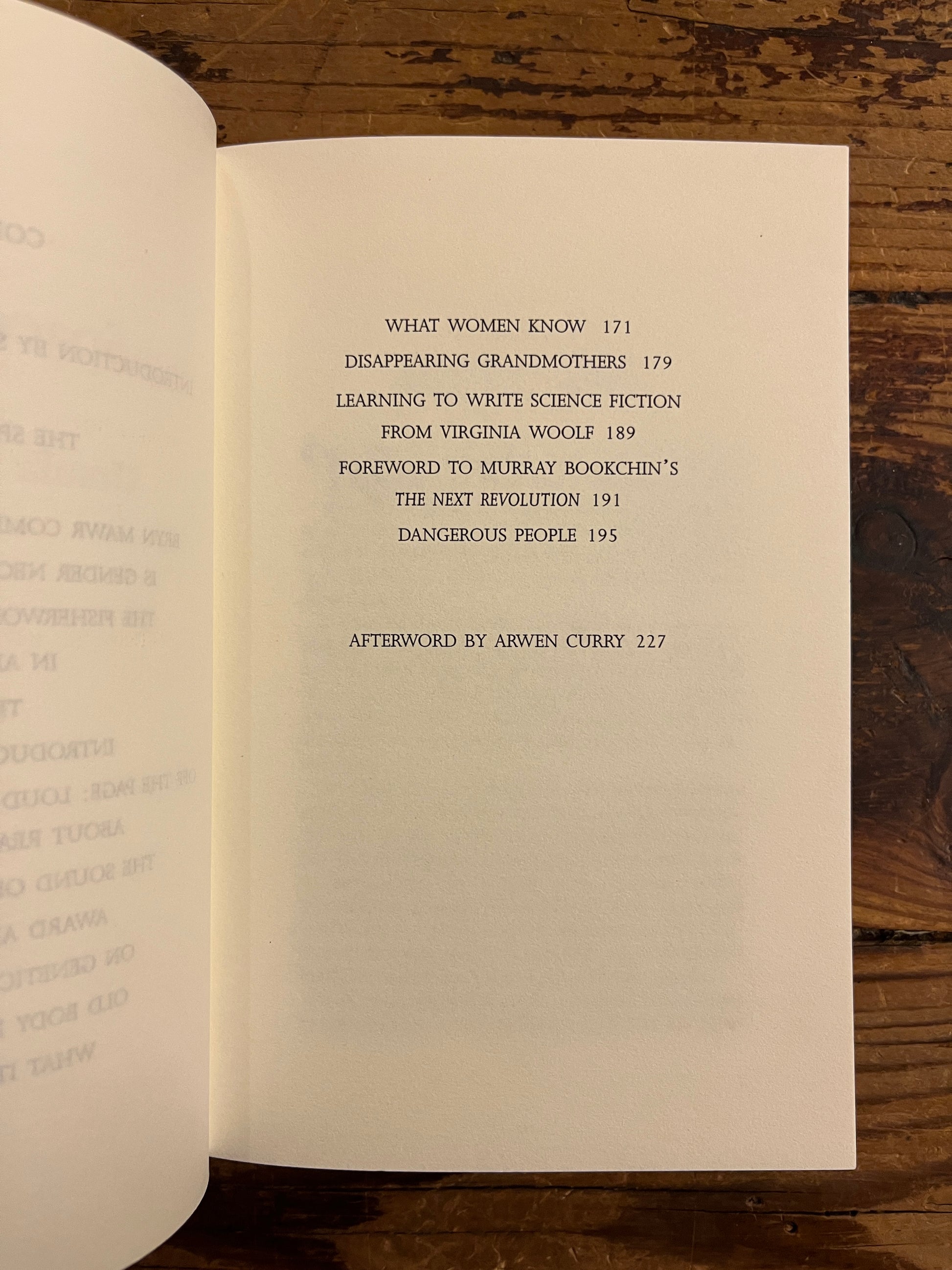 open book showing the contents of book titled 'Space Crone' by Ursula K. Le Guin on a wooden surface