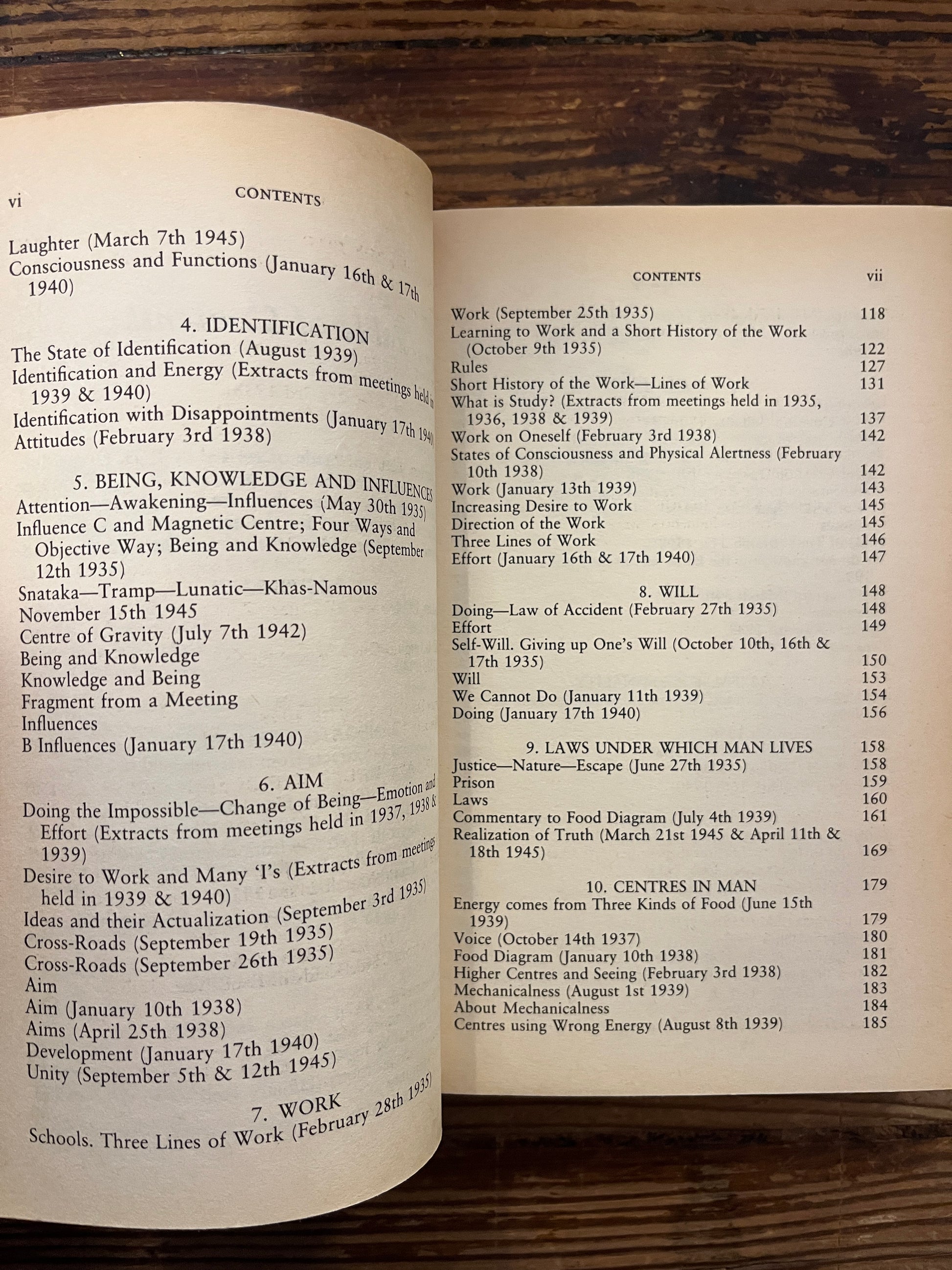 Open book titled 'a further record' by P.D. Ouspensky on a wooden surface 