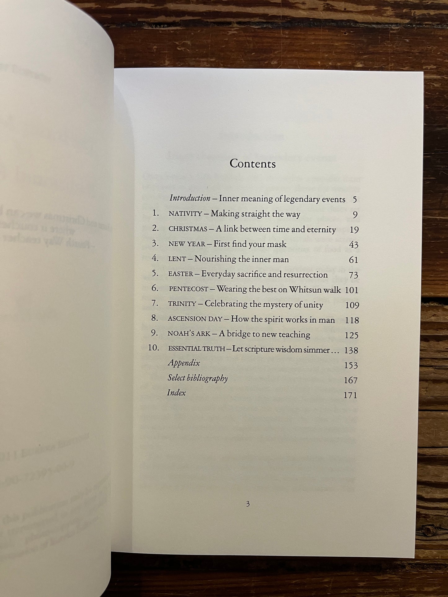 Open book titled 'The Inner Meaning of Traditional Festivals' by Bob Hunter on a wooden surface