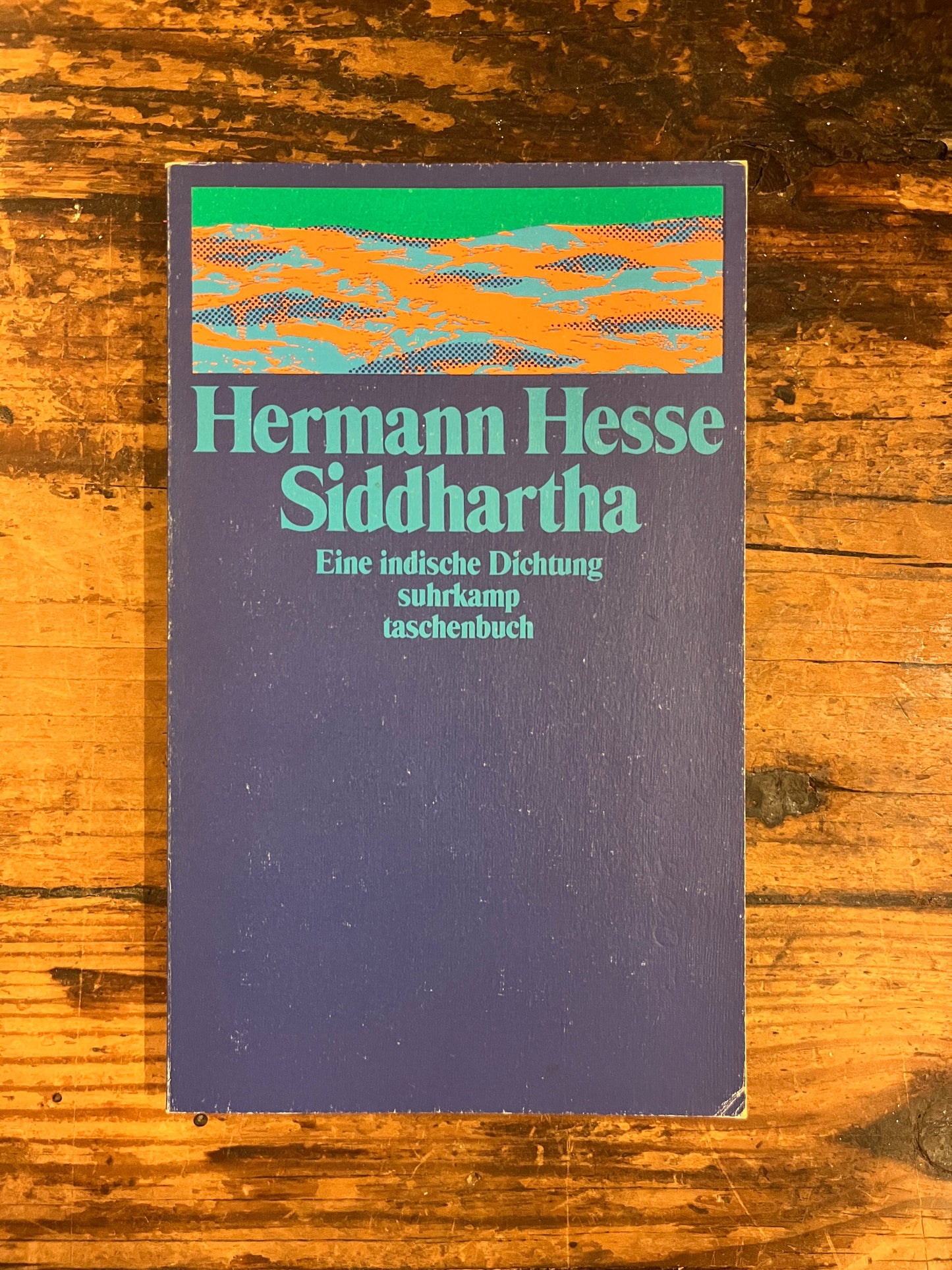 photo from the over of the book "Siddharta"on a wooden background