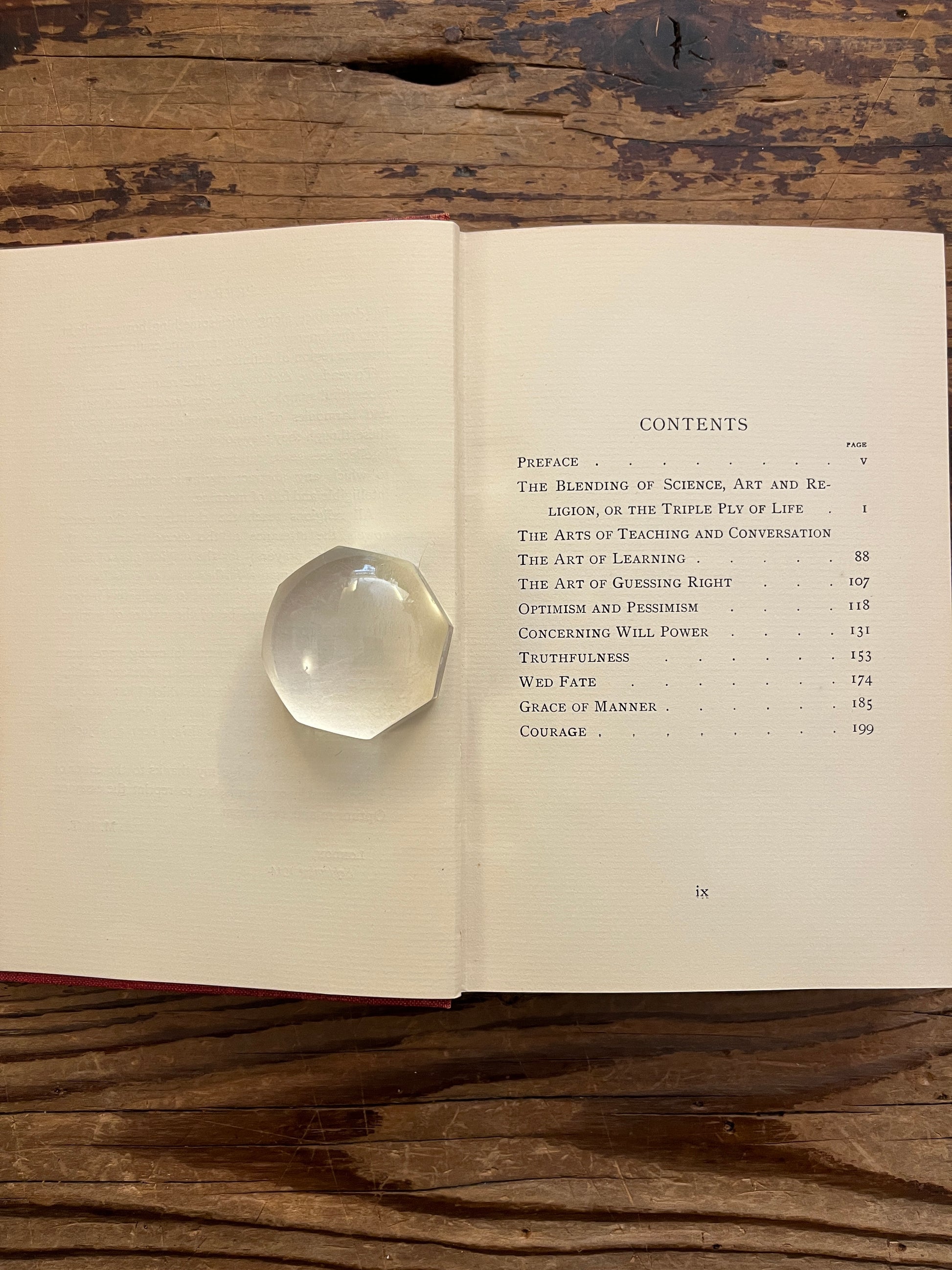 Open book titled 'The Triple Ply of Life' by Minnie E. Theobald on a wooden surface