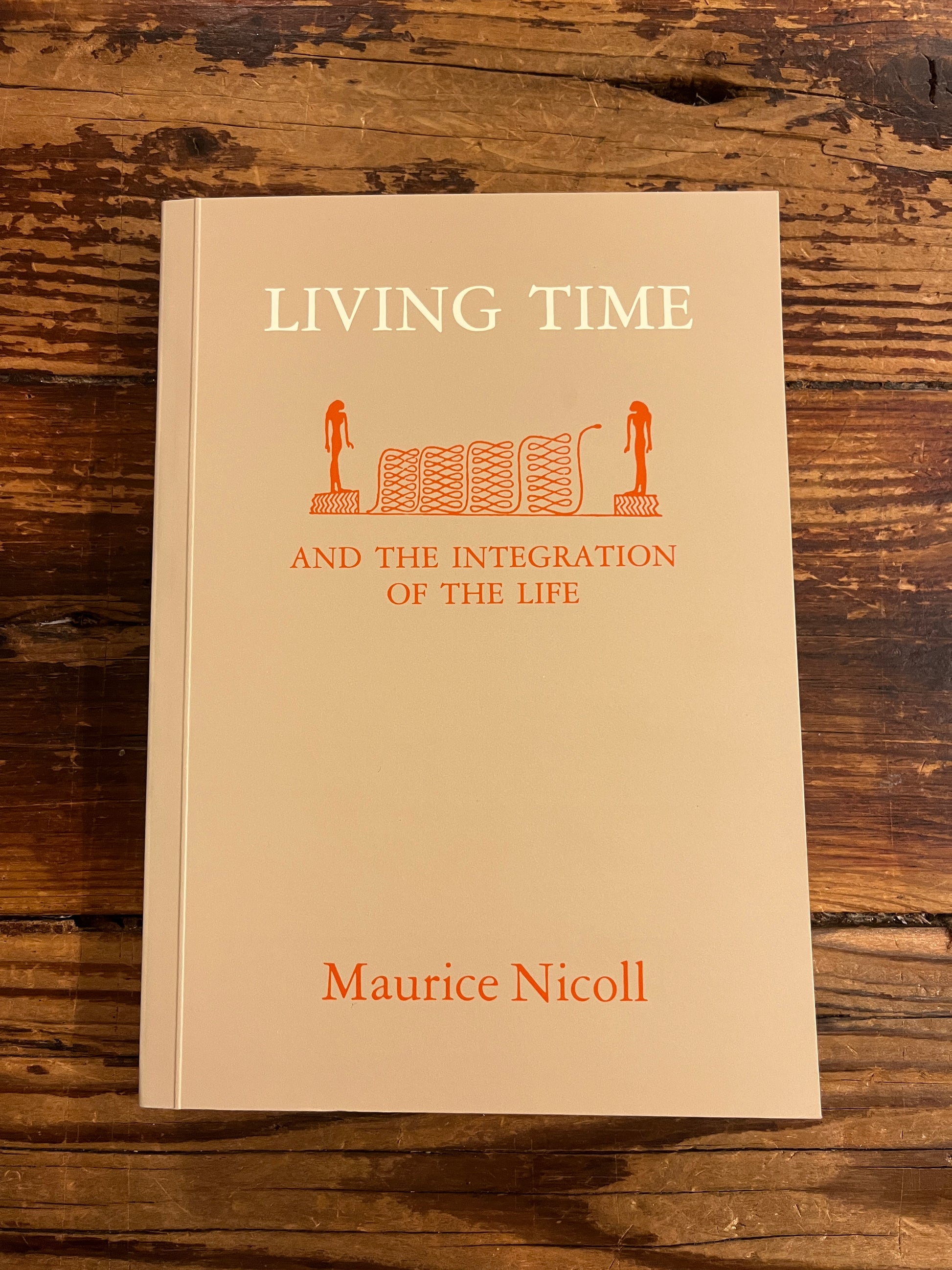 Cover of book titled 'living time' by Maurice Nicoll on wooden surface