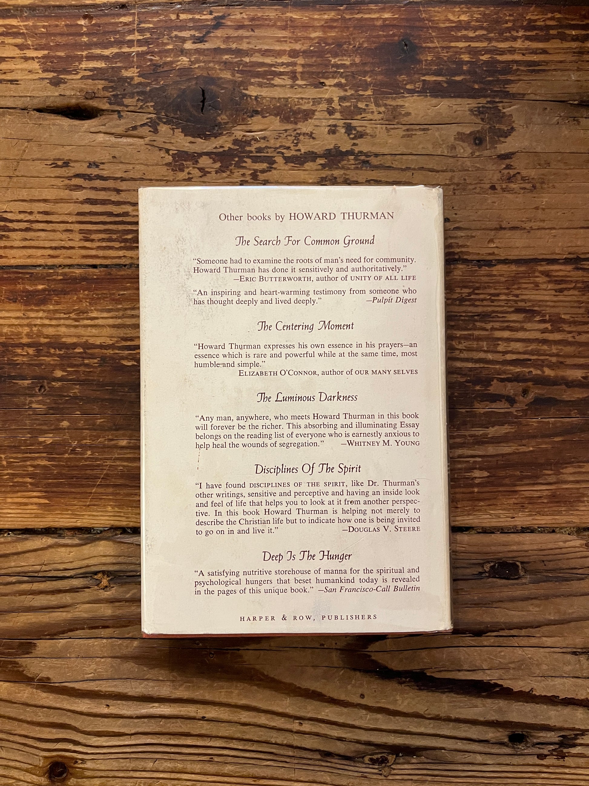 Book titled 'Meditations of the Heart' by Howard Thurman on a wooden surface