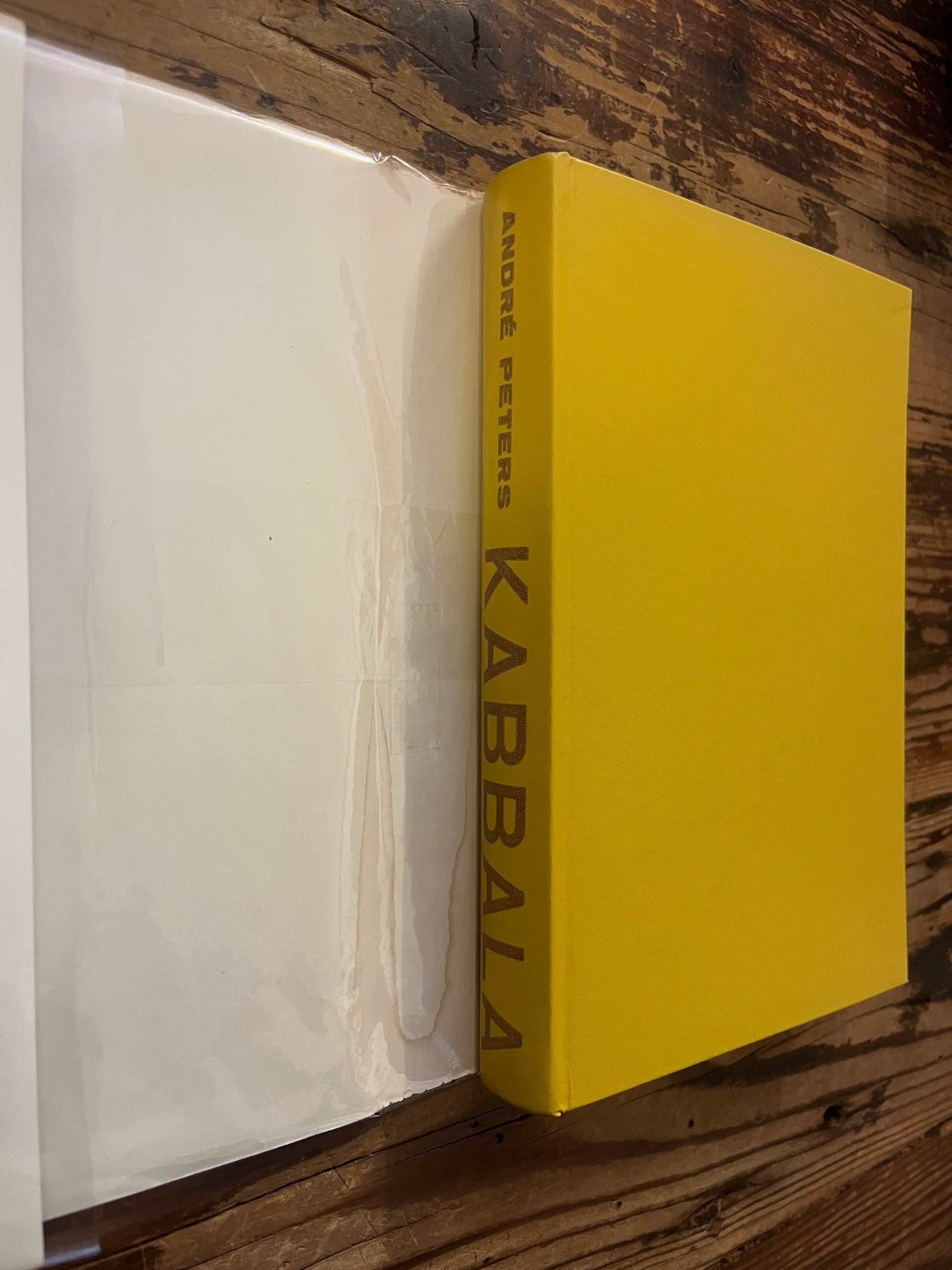 Boek met de titel 'Kabbala' door Andre Peters op een houten achtergrond
