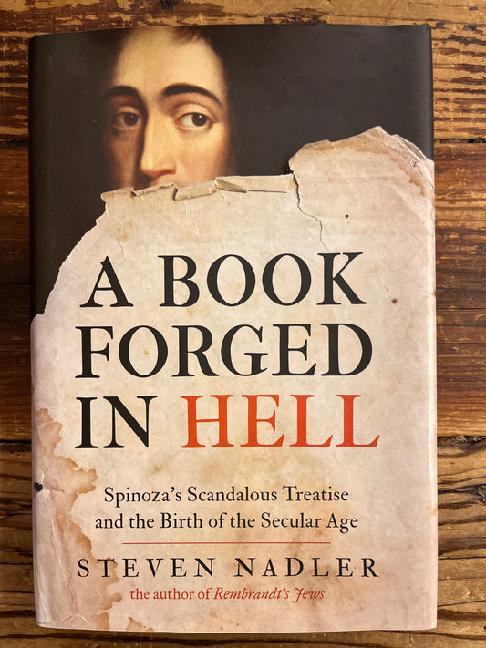 front cover of book titled 'A Book Forged in Hell' by Steven Nadler on a wooden surface