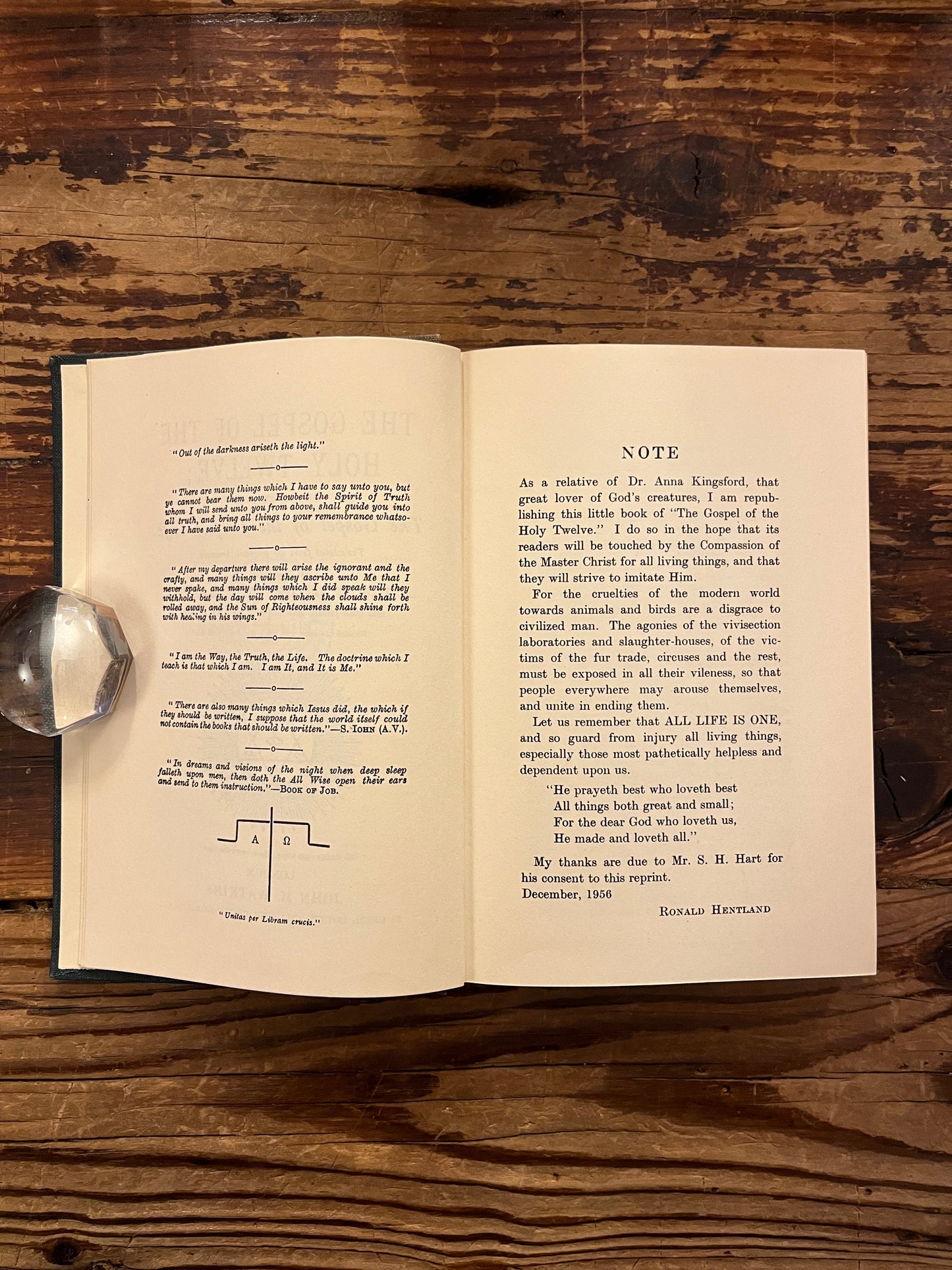 Open book titled 'The Gospel of the Holy Twelve' by J.R. Ouseley on a wooden surface