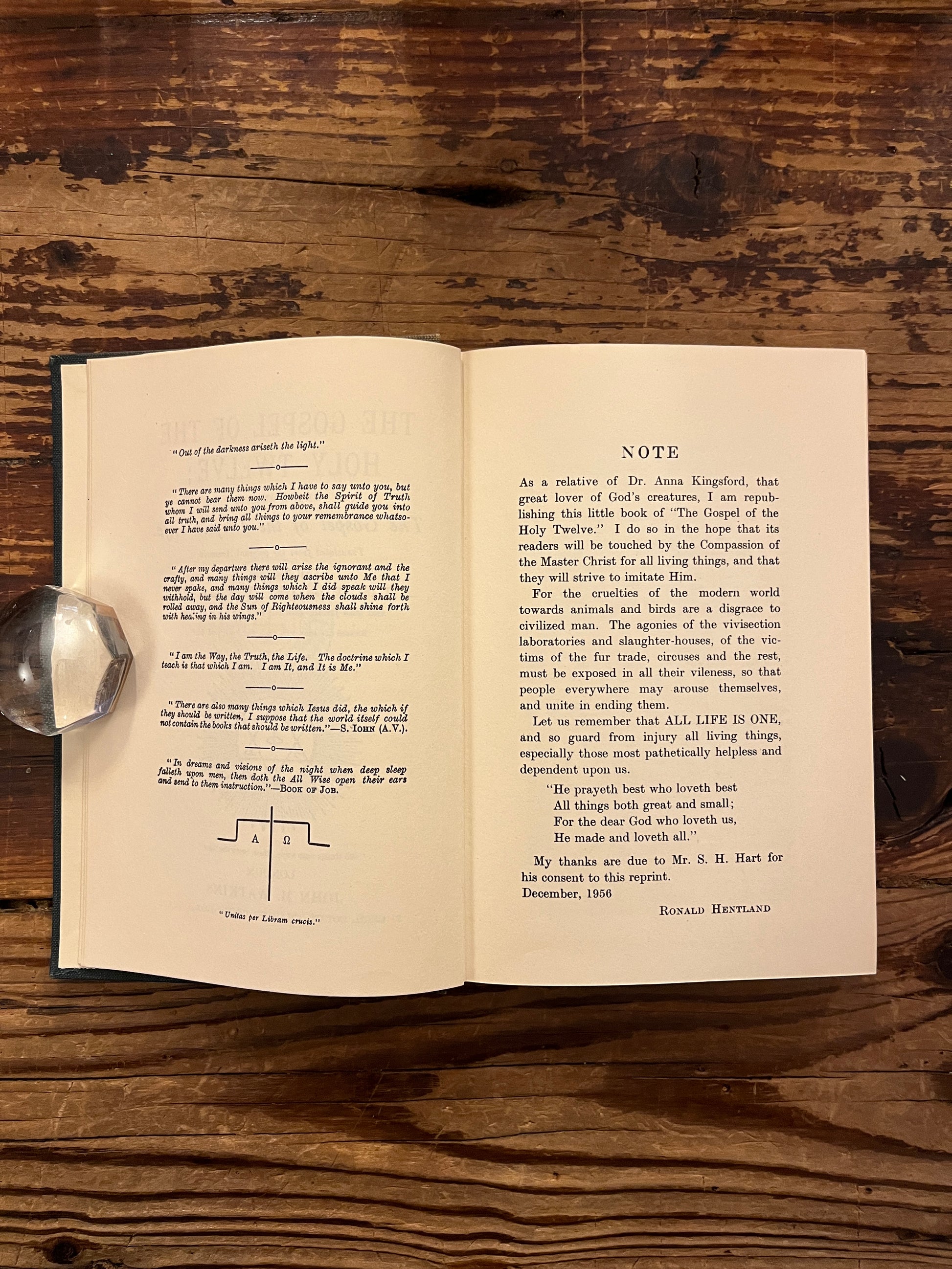 Open book titled 'The Gospel of the Holy Twelve' by J.R. Ouseley on a wooden surface