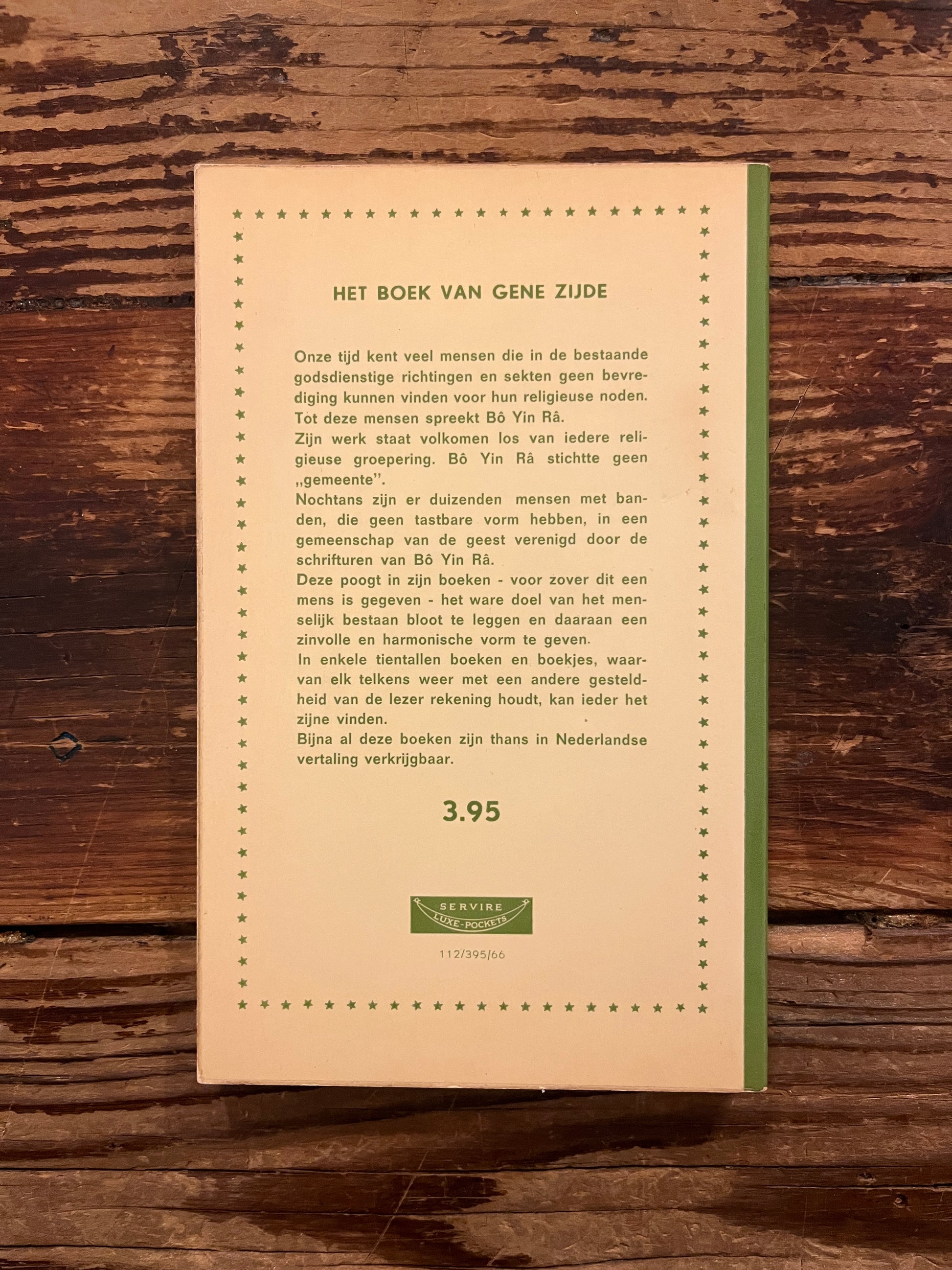 Achterkant van boek 'Het Boek van Gene Zijde' door Bo Yin Ra op een houten tafel 
