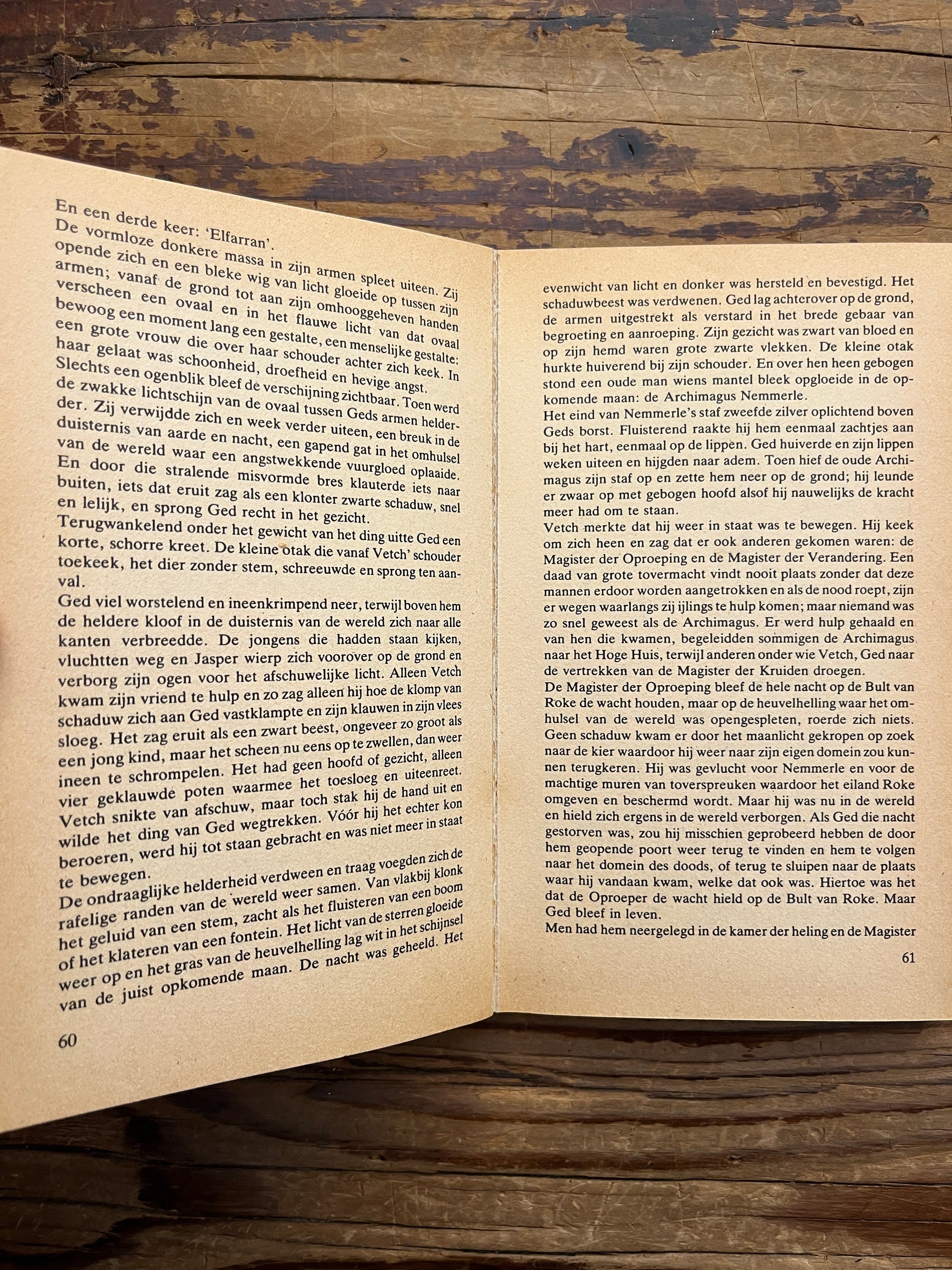 Open boek, deel 1 van de  'Aardzee' trilogie door Ursula K. Le Guin op een houten achtergrond