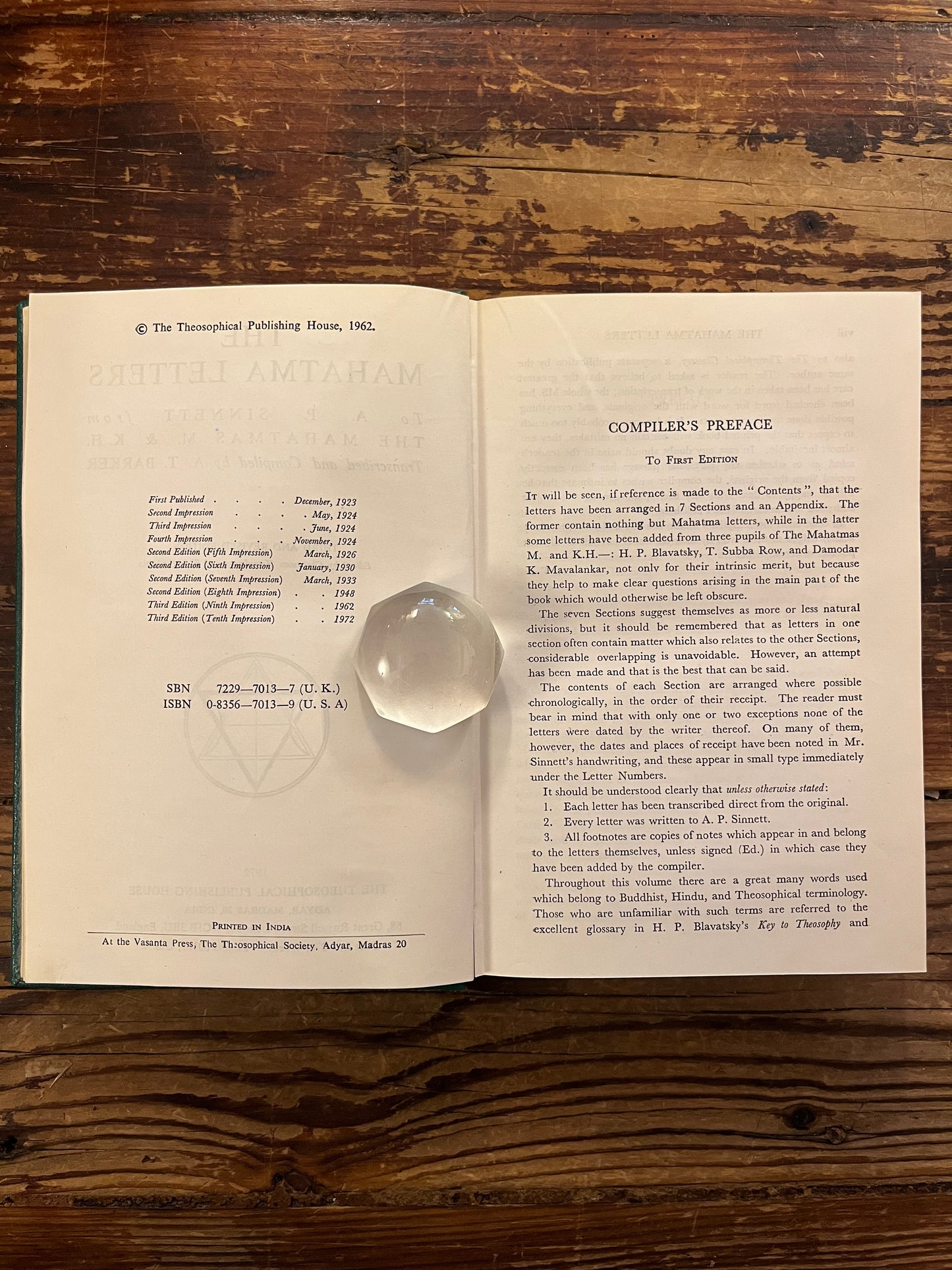 Open book titled 'the Mahatma letter to A.P. Sinnett' on a wooden surface 