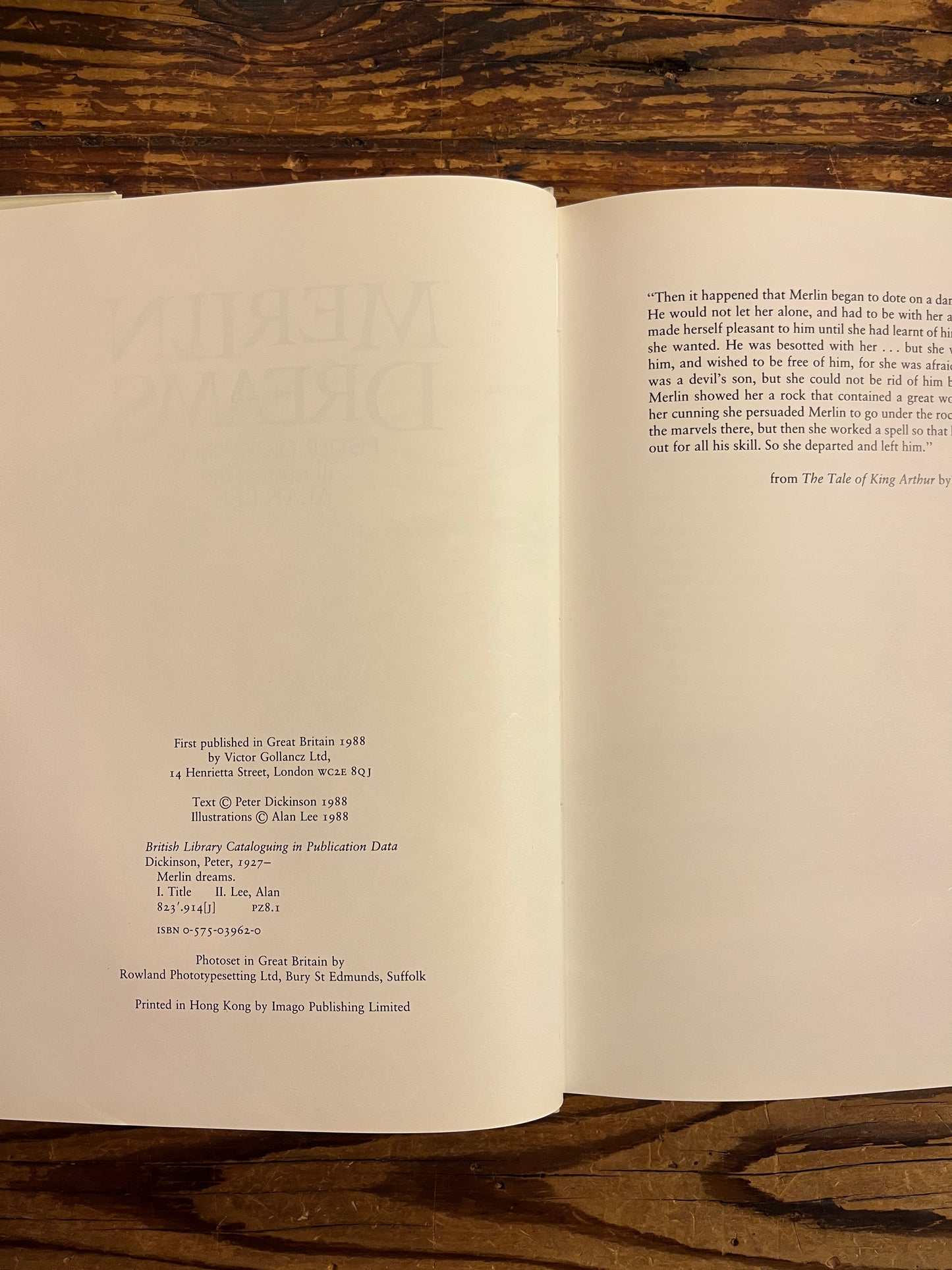 Publishers details of book titled 'Merlin Dreams' by Peter Dickinson and illustrated by Alan Lee on a wooden surface 