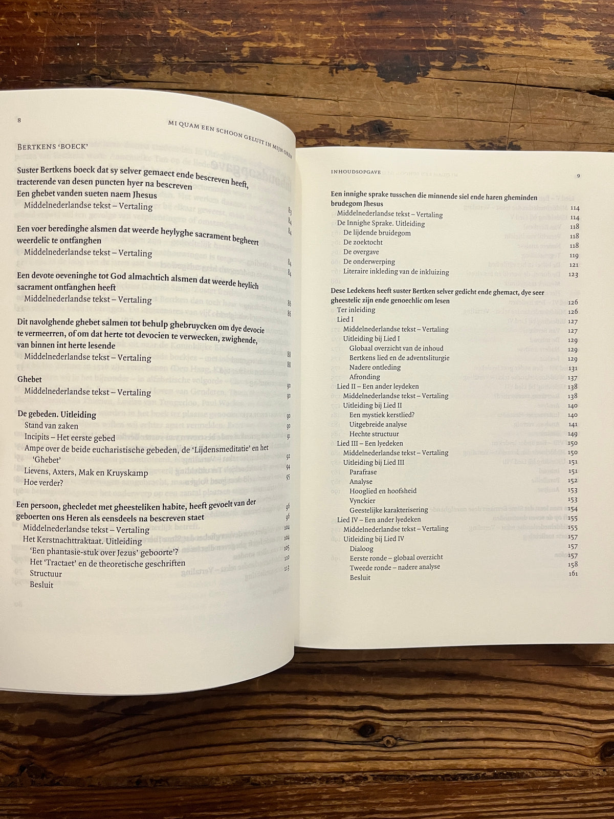 Open boek met de titel 'het werk van Suster Bertken' op een houten achtergrond
