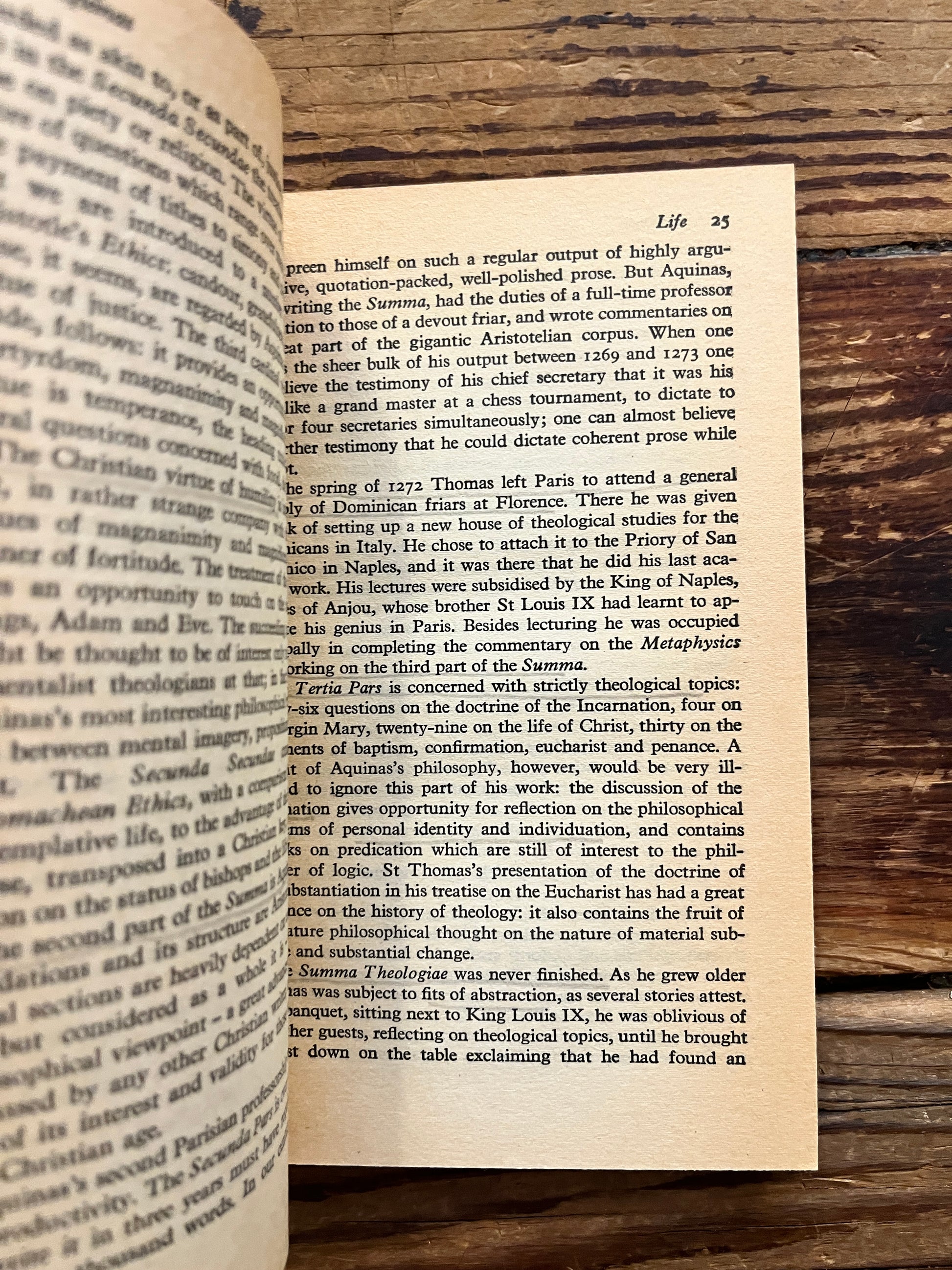 Open book showing pencil undtitled 'Aquinas by Anthony Kenny on a wooden surface