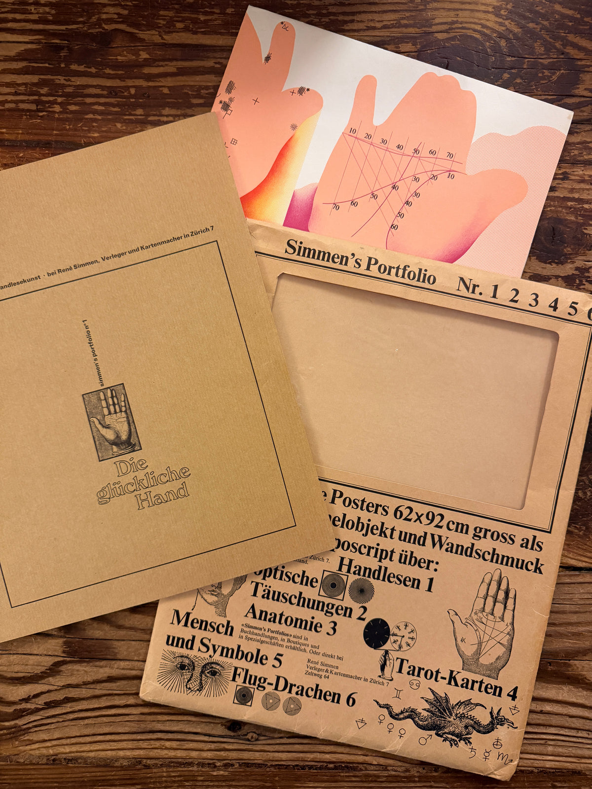 Front covers of the complete 'Simmen's Portfolio No. 1: Die glückliche Hand' on a wooden background 