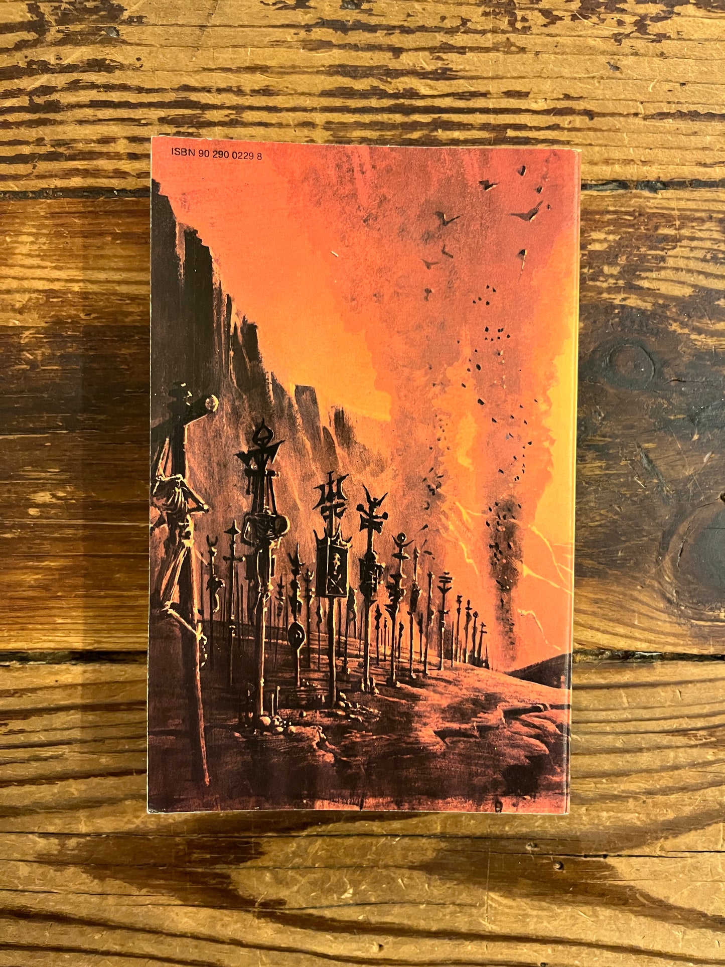 Achterkant van boek met de titel 'Duin Messias' door Frank Herbert op een houten achtergrond