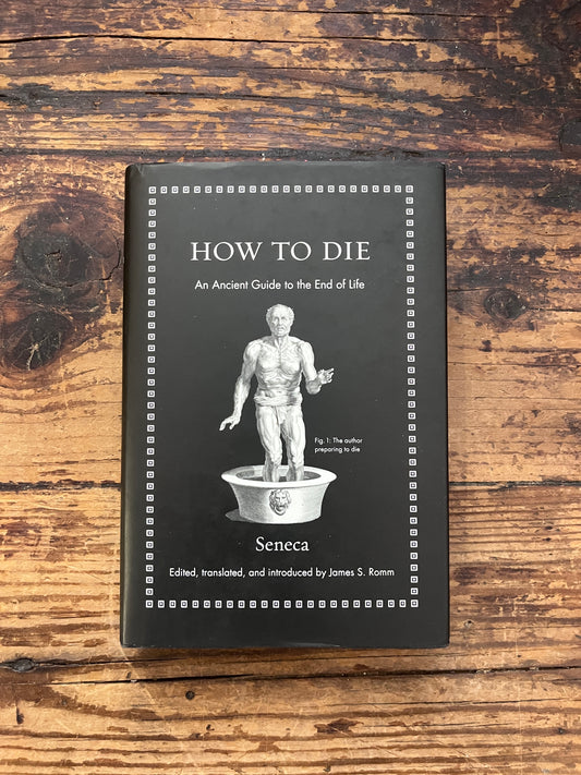 photo of the cover of the book "how to die" on a wooden background