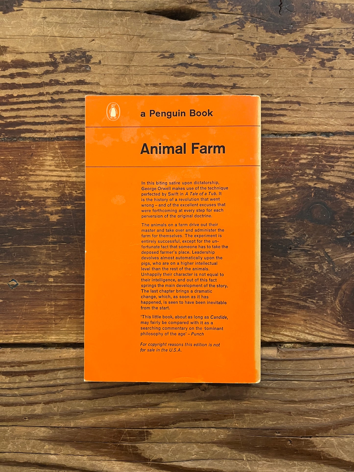 Back cover of book titled 'Animal farm' by George Orwell on a wooden surface