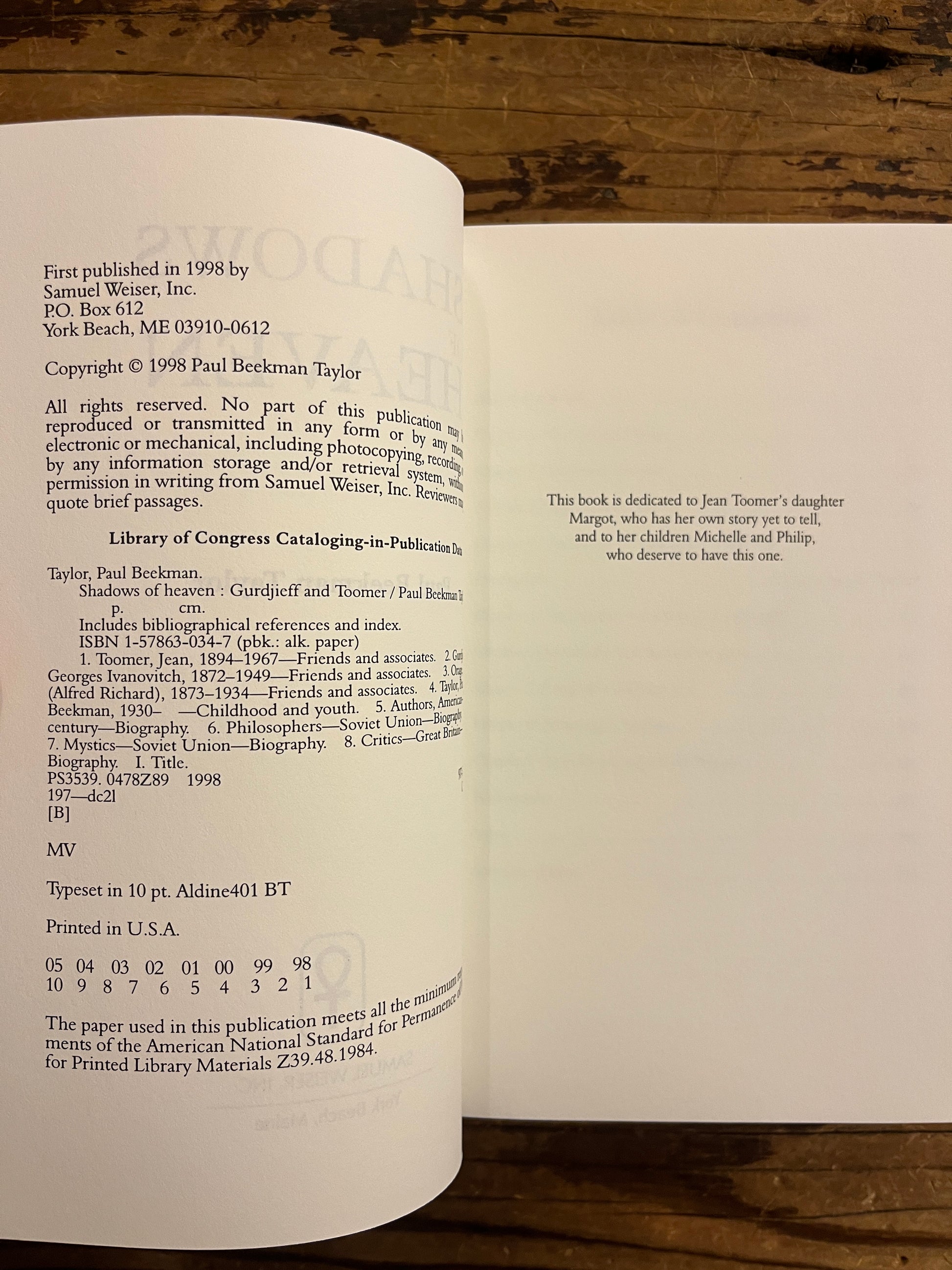 publisher page of book titled 'Shadows of Heaven Gurdjieff and Toomer' by Paul Beekman Taylor on a wooden surface