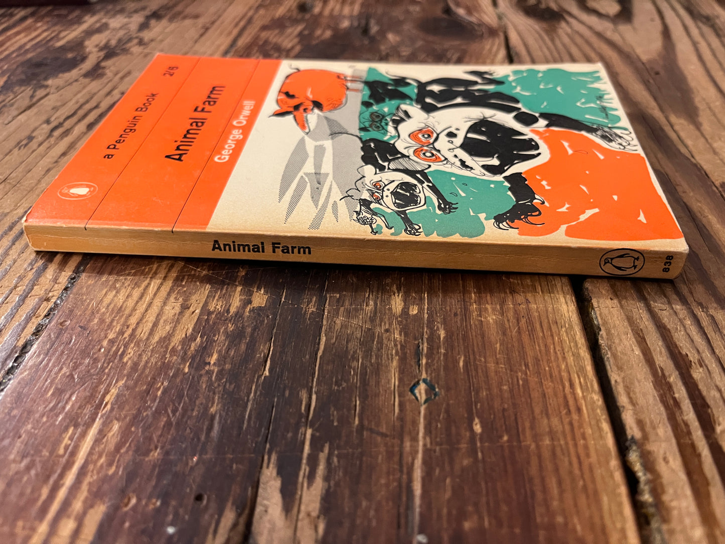 Spine and front cover of book titled 'Animal farm' by George Orwell on a wooden surface