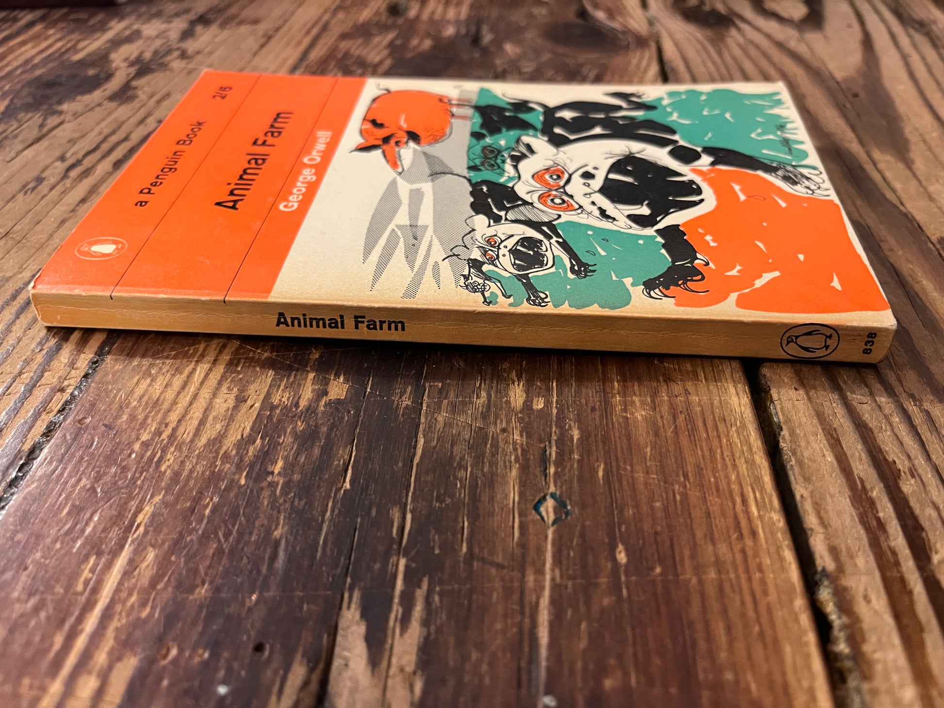Spine and front cover of book titled 'Animal farm' by George Orwell on a wooden surface