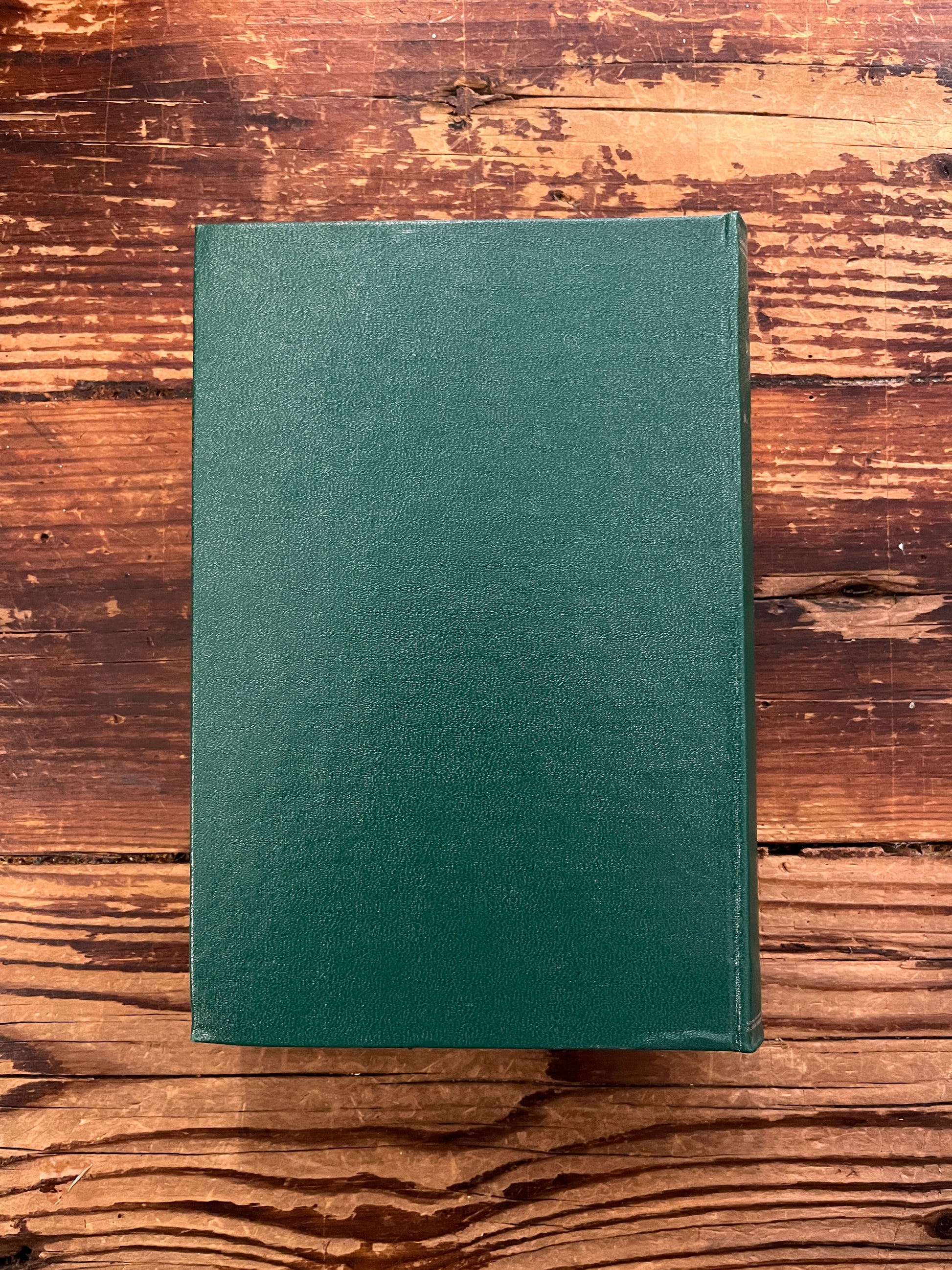 Book without dust jacket titled 'the Mahatma letter to A.P. Sinnett' on a wooden surface 