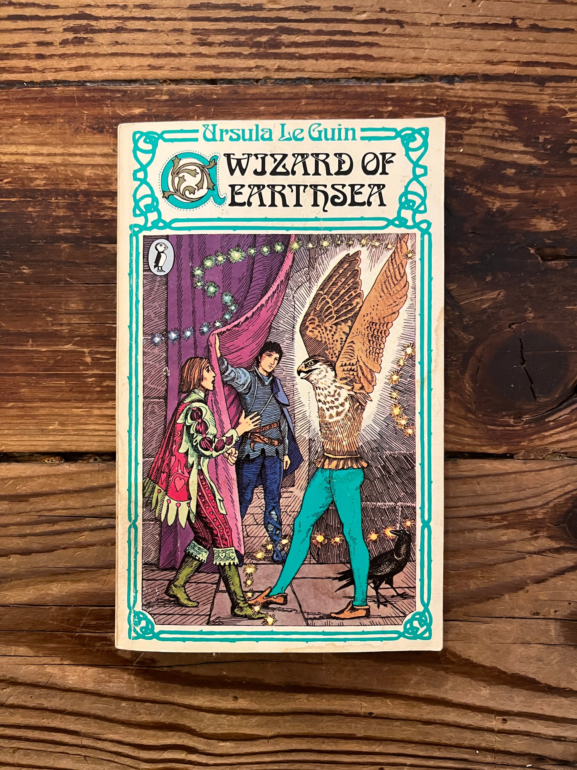 Cover of book 'a Wizard of Earthsea' by Ursula K. Le Guin on a wooden surface 