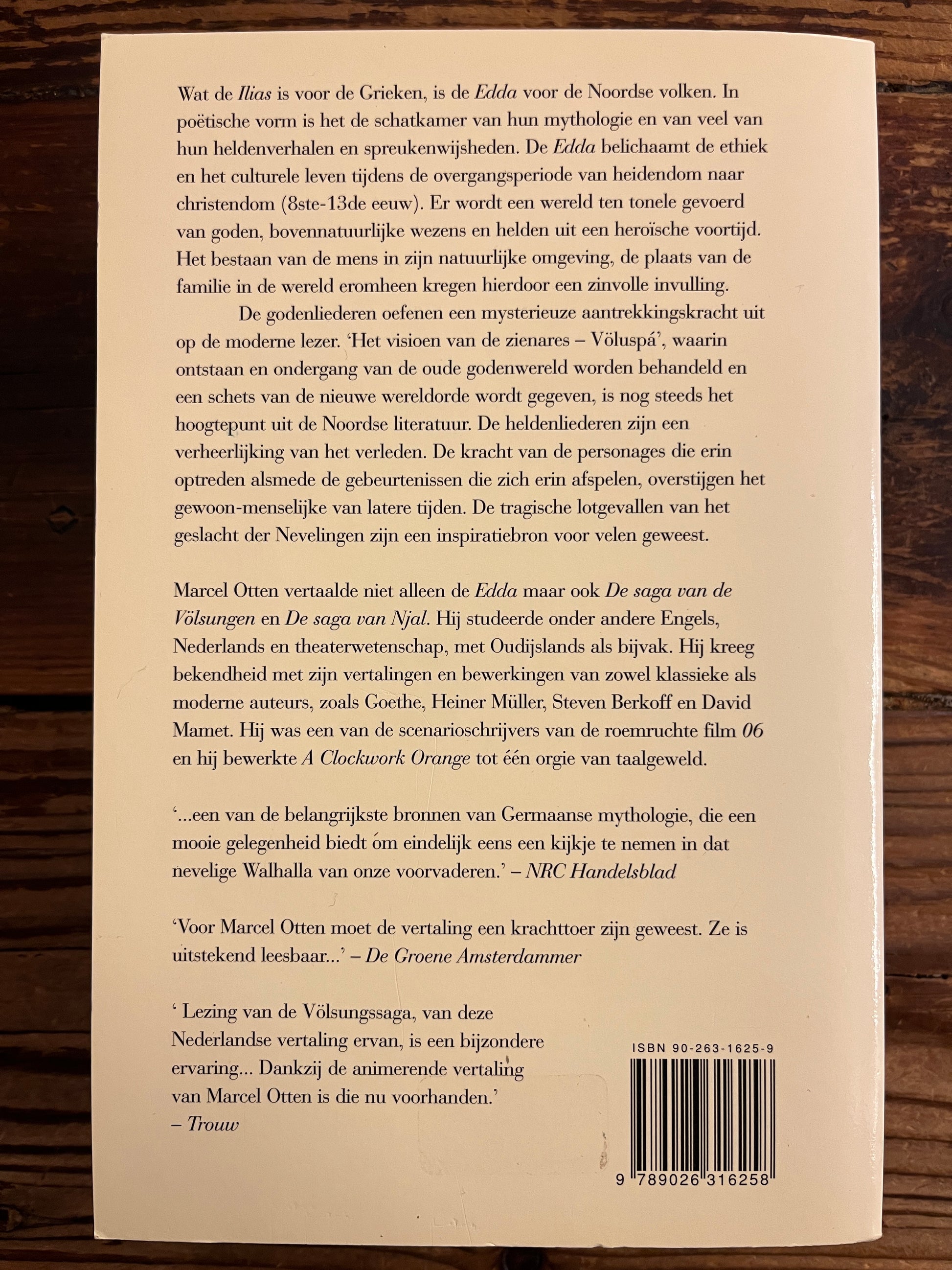Back cover of a book with text and a barcode on a wooden surface