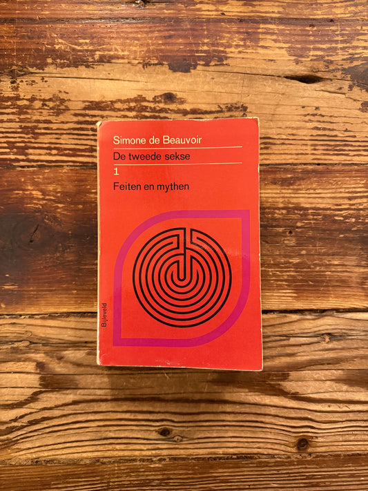 Voorkant van boek met de titel 'de tweede sekse 1' door Simone de Beauvoir op een houten achtegrond 