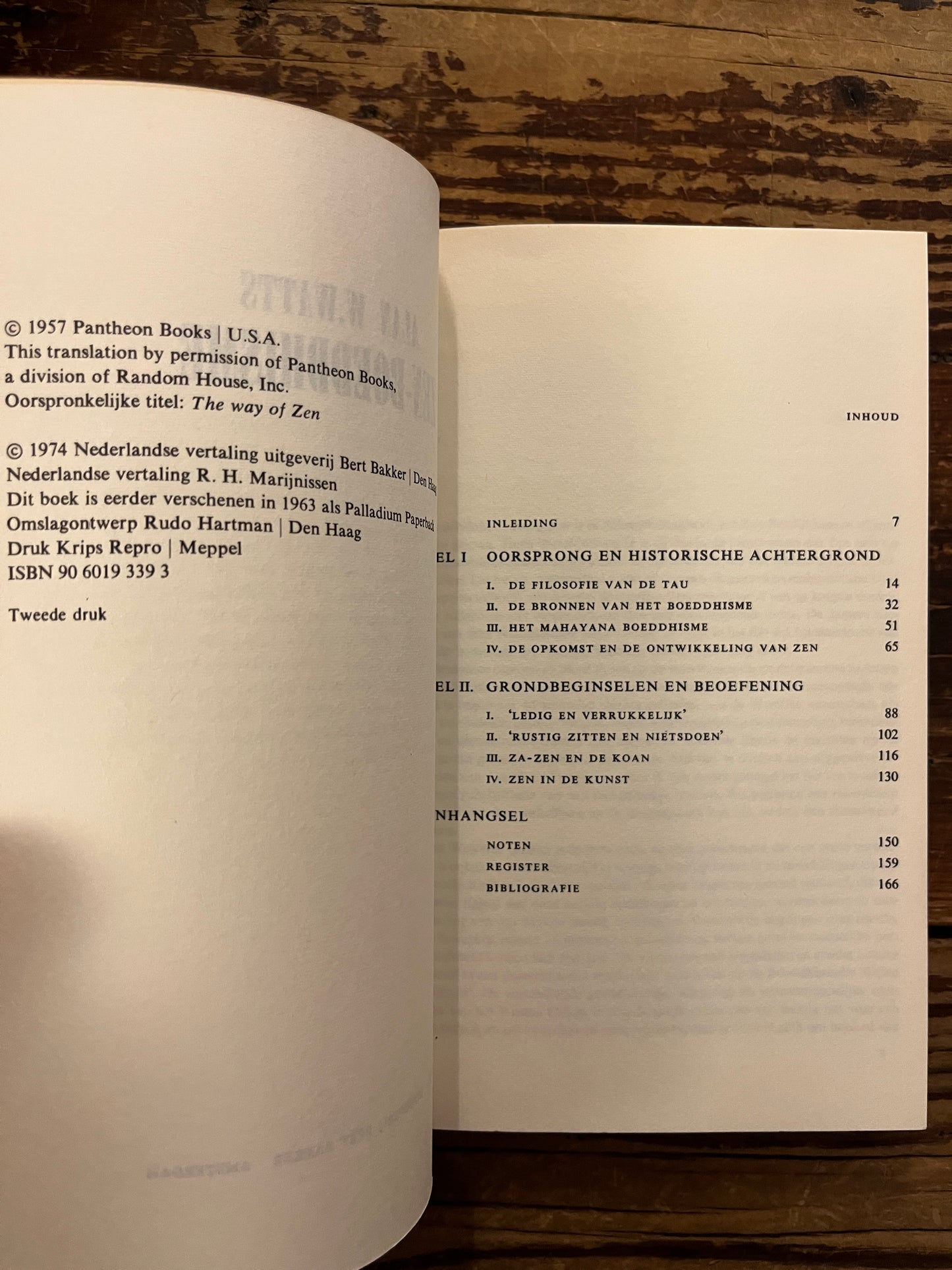 Open boek met de titel 'zen-boeddhisme' door Alan W. Watts op een houten achtergrond 