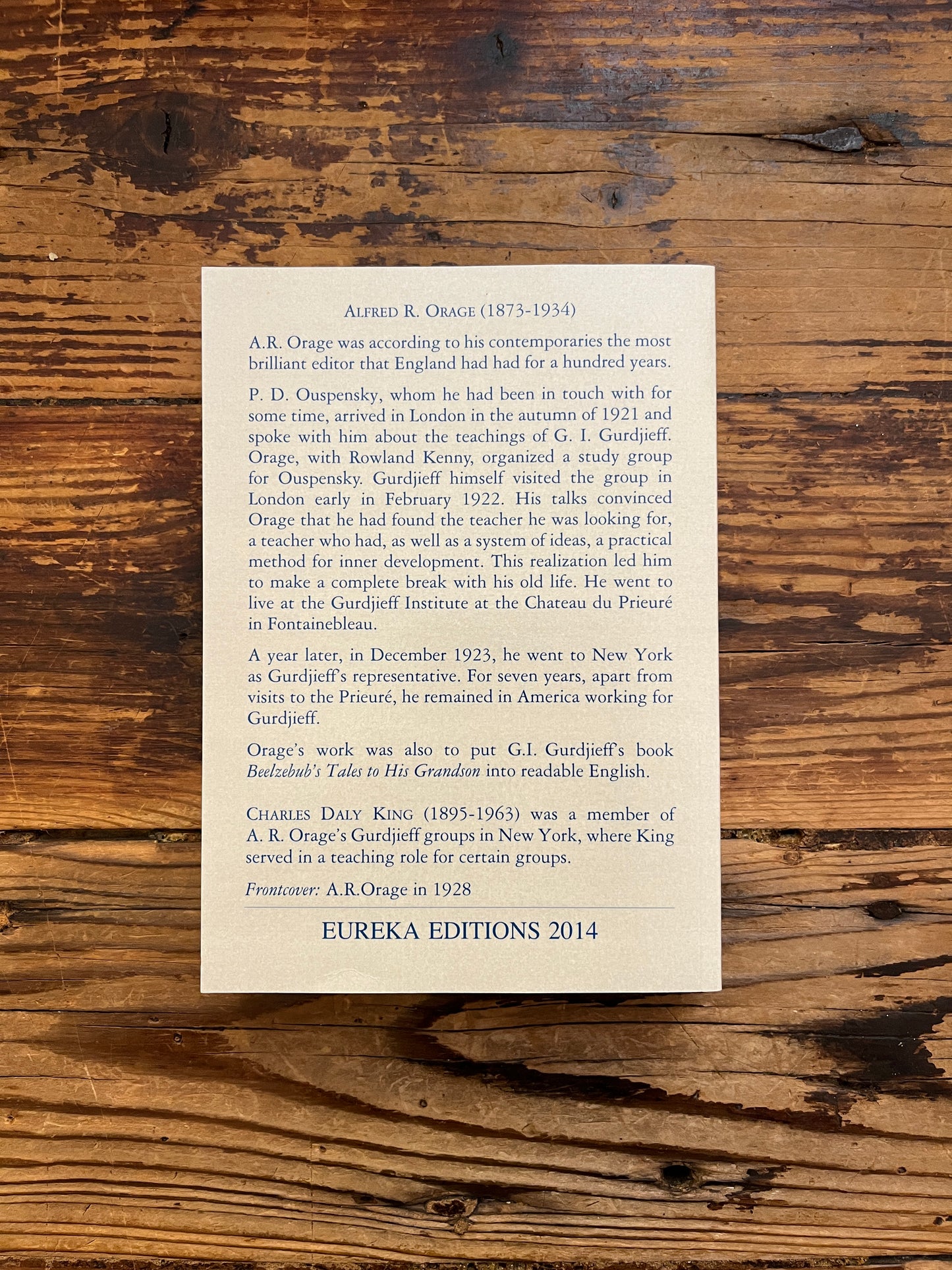 Back cover of book titled 'The Oragean Version' by C. Daly King on a wooden surface