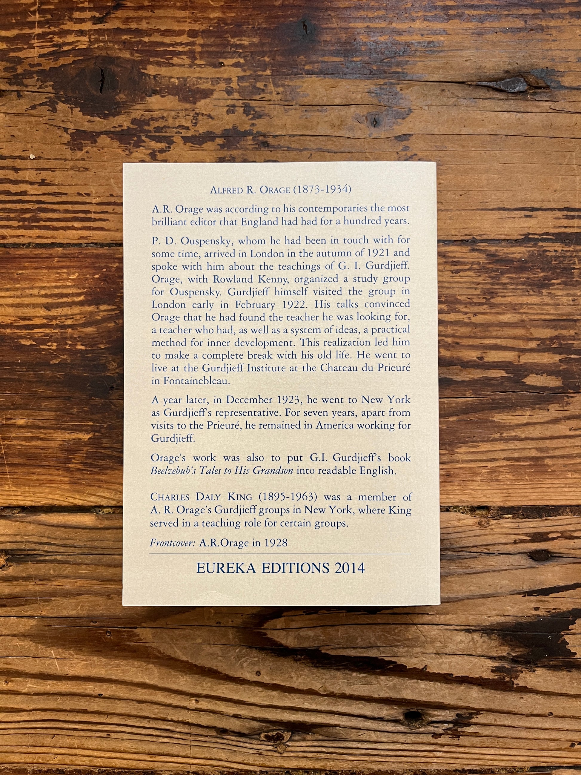 Back cover of book titled 'The Oragean Version' by C. Daly King on a wooden surface