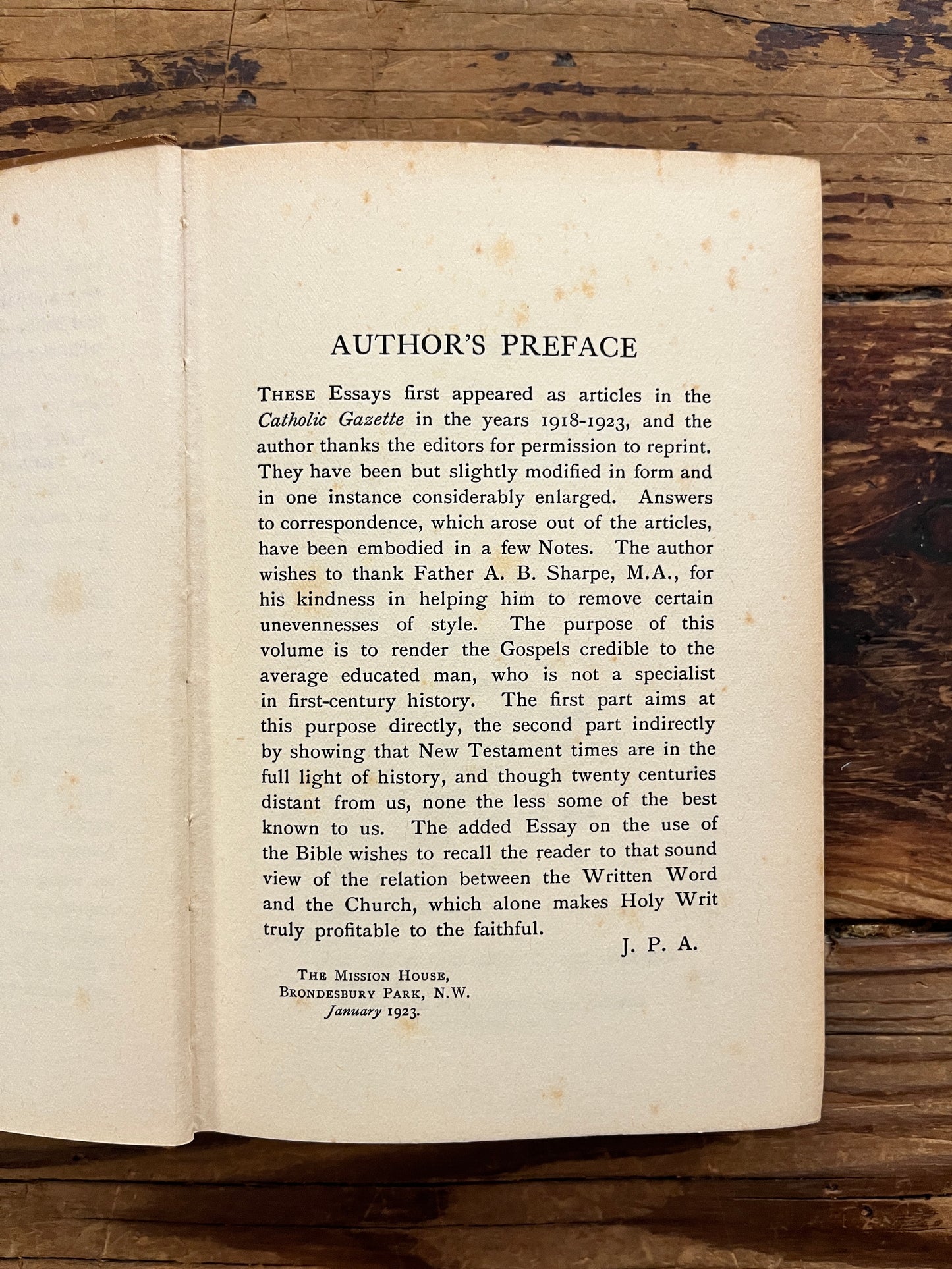 Open book with the title 'the gospels, fact, myth or legend ? by J.P. Arendzen Ph.D. on a wooden surface