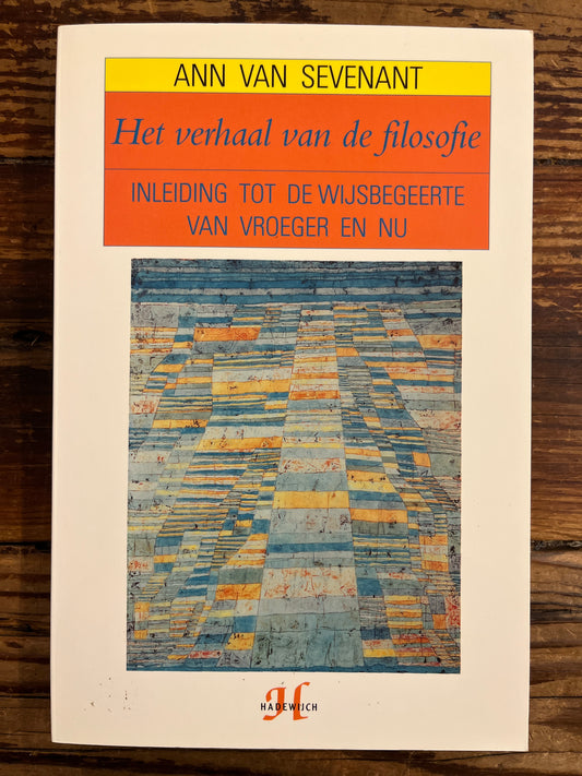 Voorkant van boek met titel 'het verhaal van de filosofie' door Ann van Sevenant op een houten achtergrond 